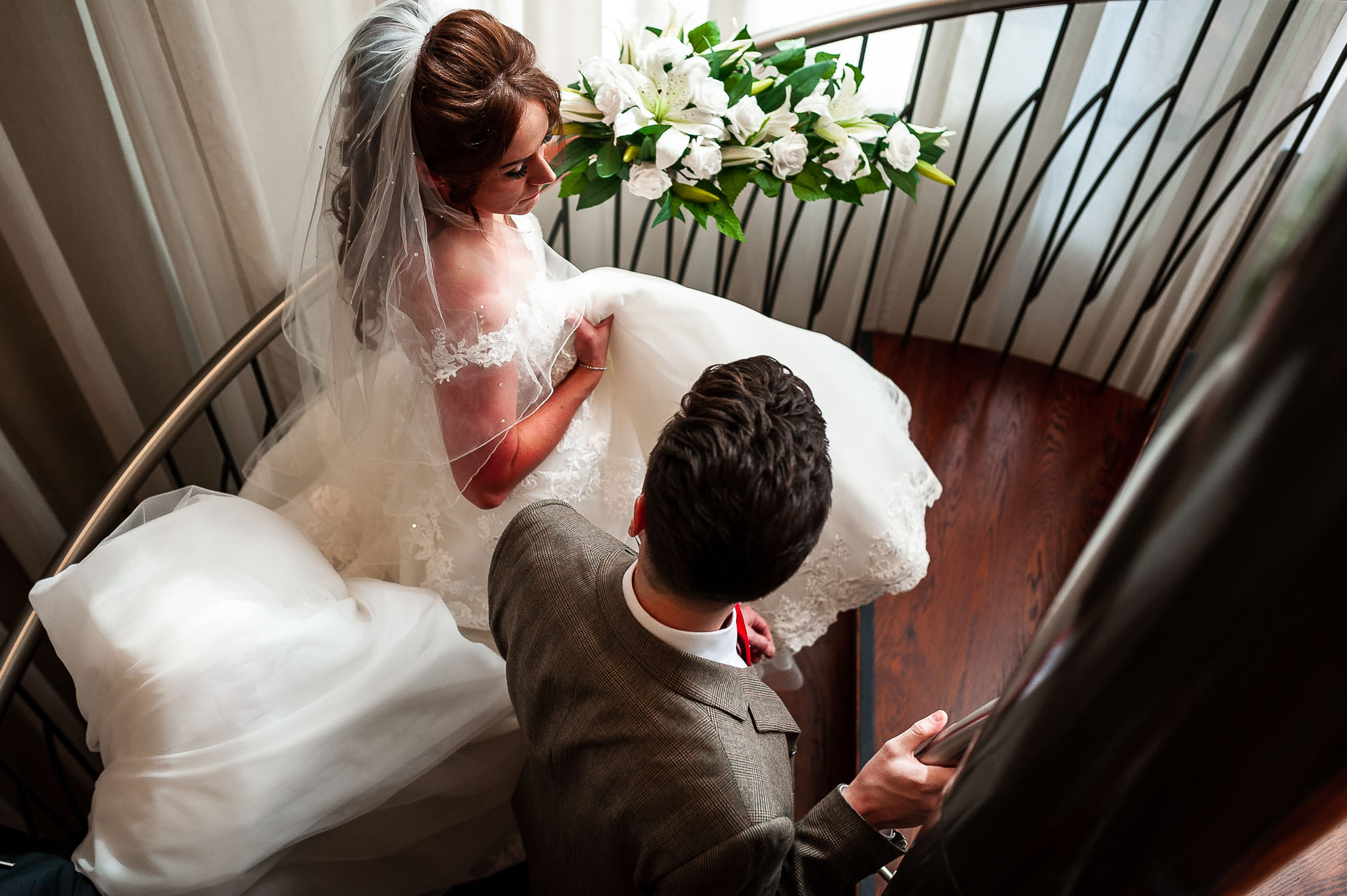 The happy couple walk up spiral staircase
