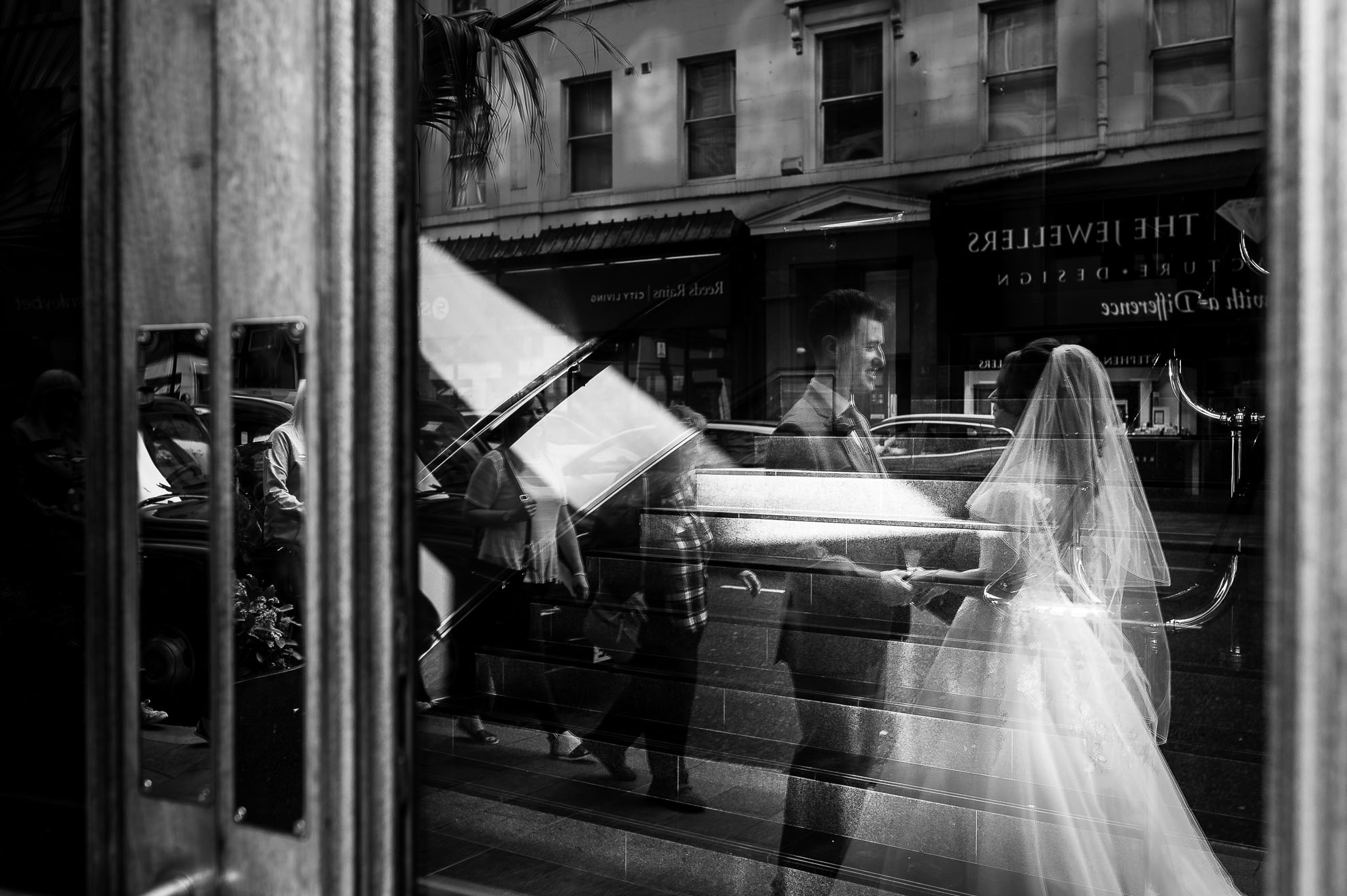 Bride and groom reflected in glass