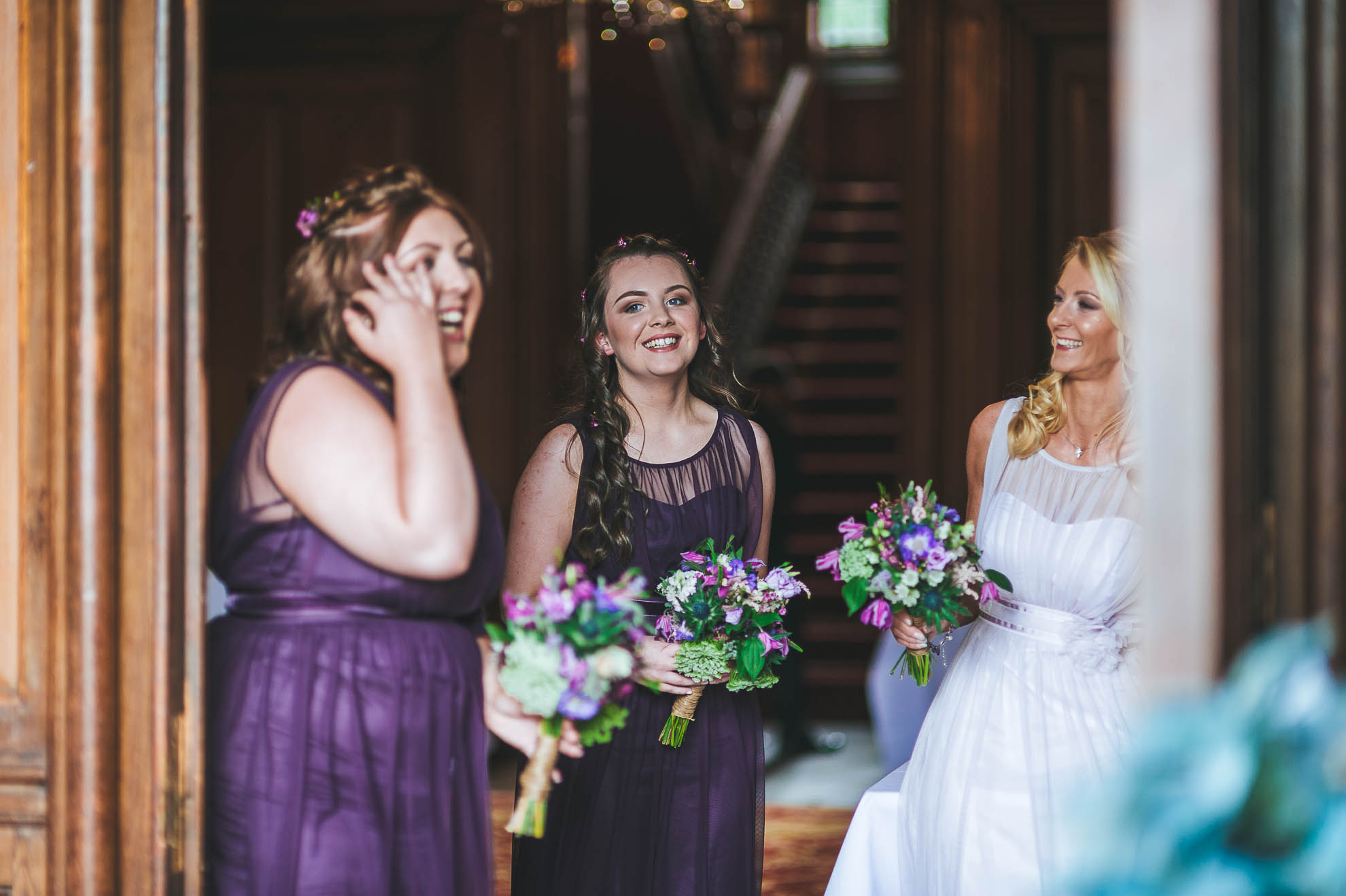 Bridesmaids wait at entrance of venue