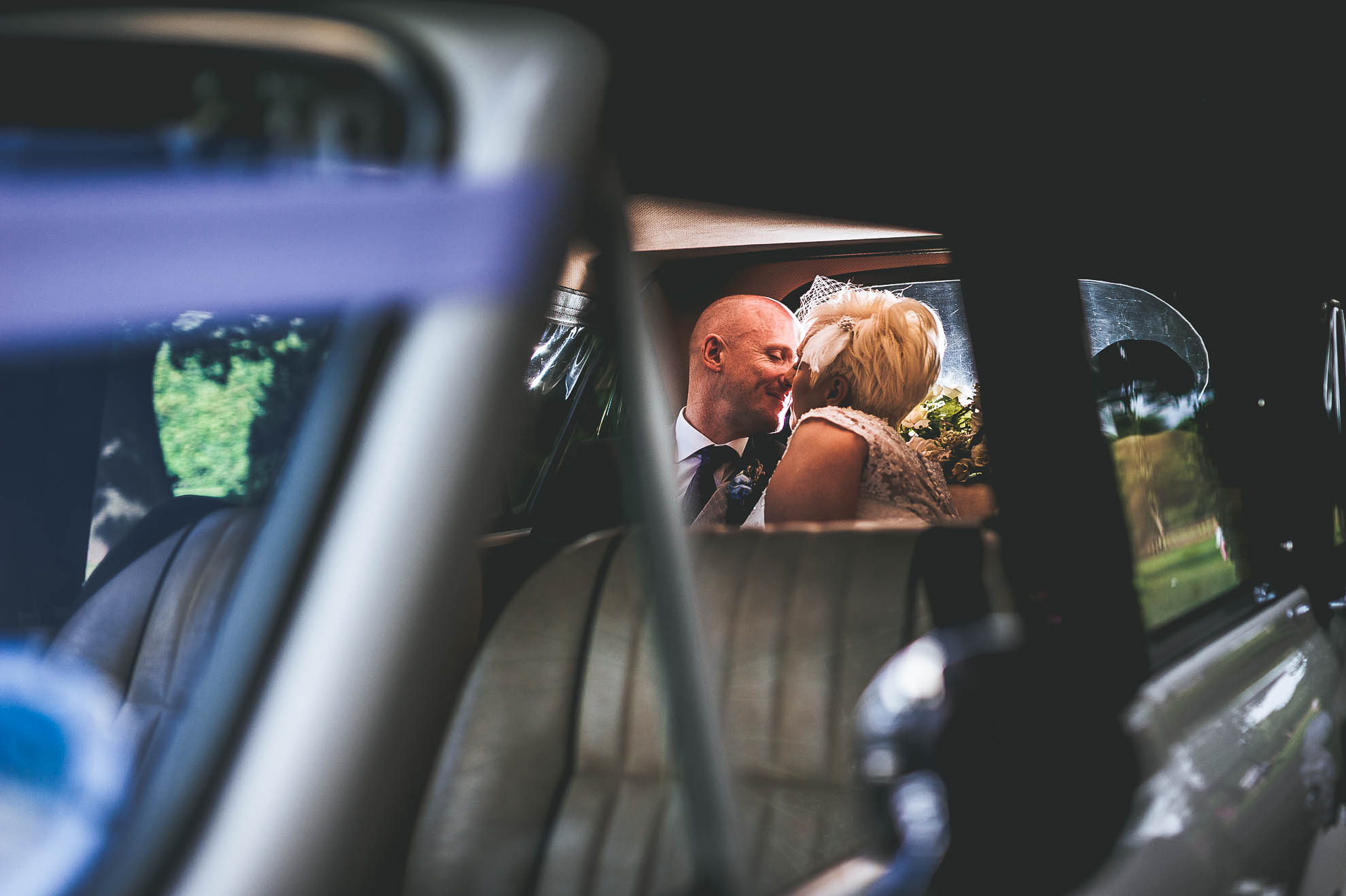 Bride and groom in the back of the wedding car