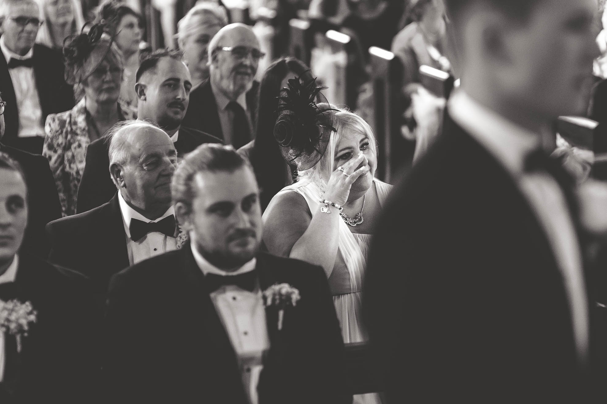 Mother of the groom wipes away a tear