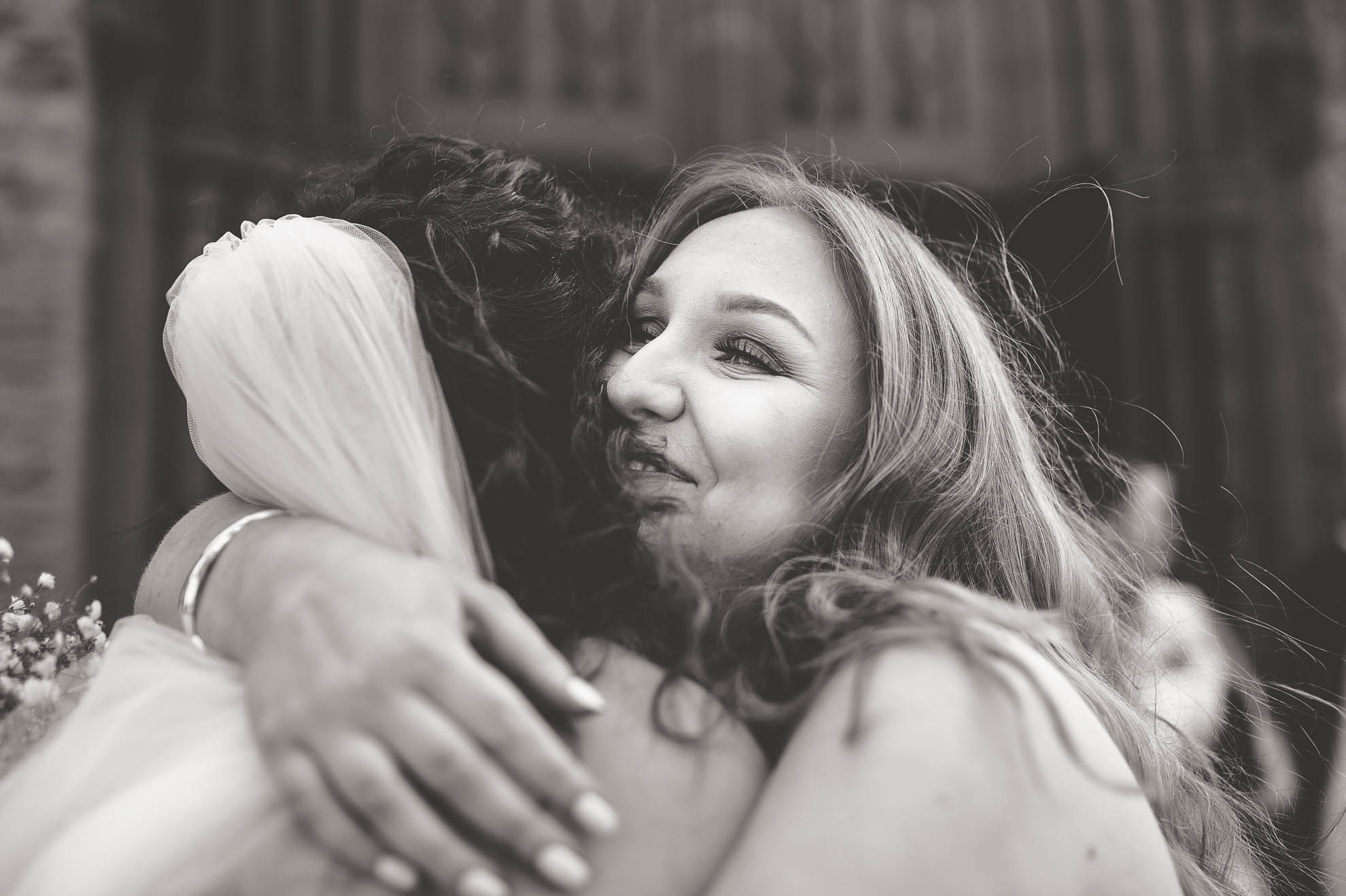 Bridesmaid hugs the bride