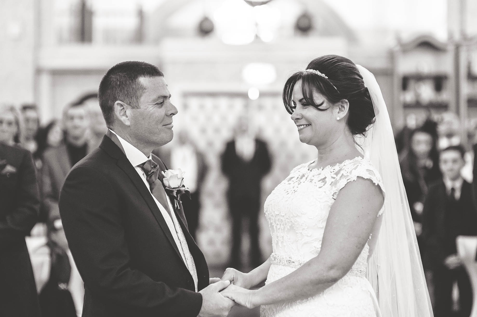 Bride and groom smile at each other during the vows