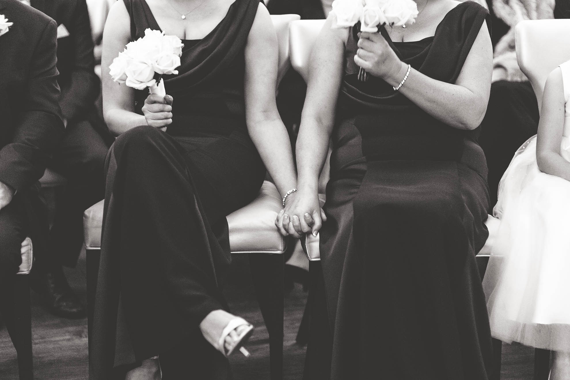 Bridesmaids holding hands during the ceremony