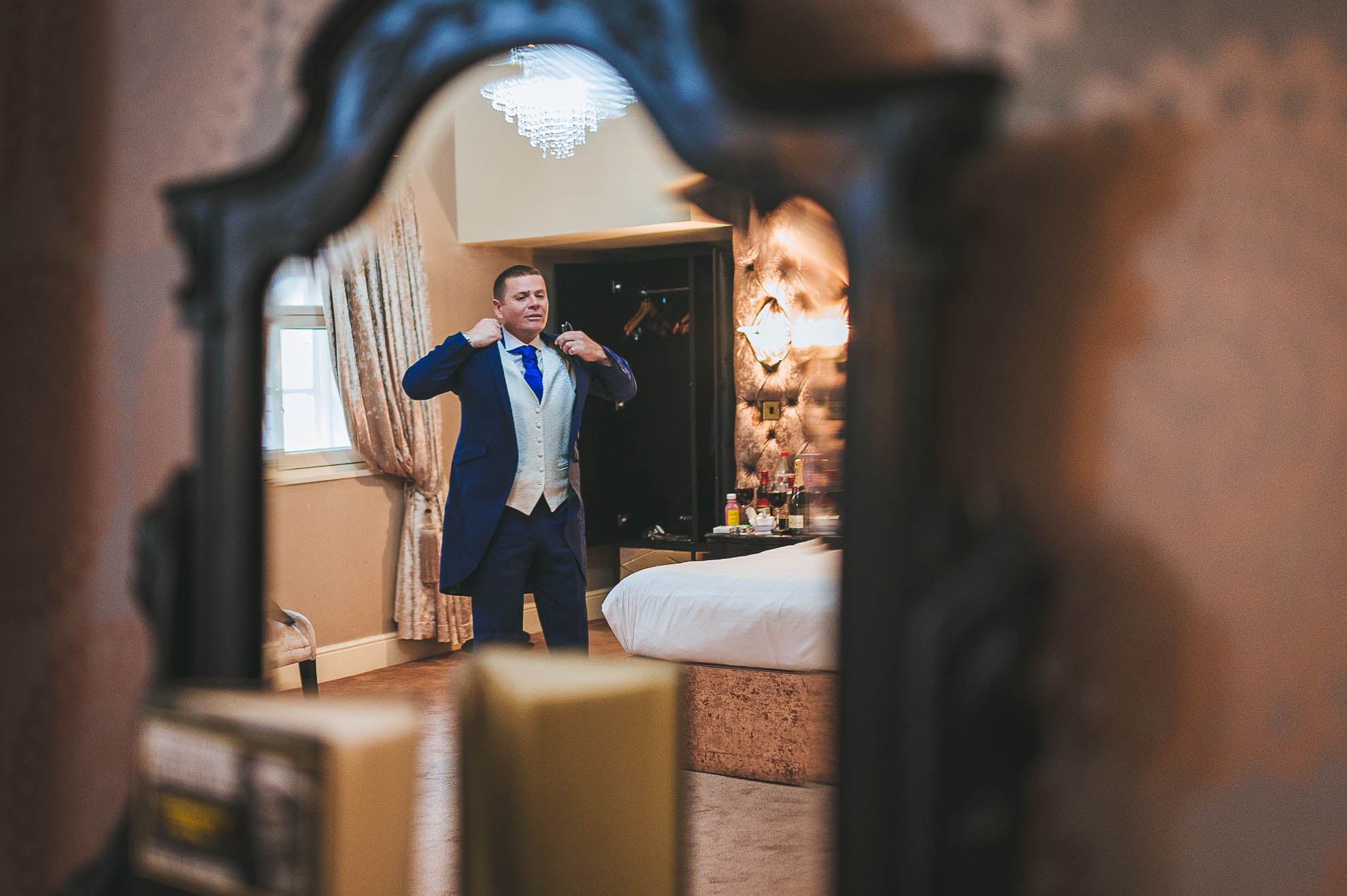 Groom getting ready reflection in mirror
