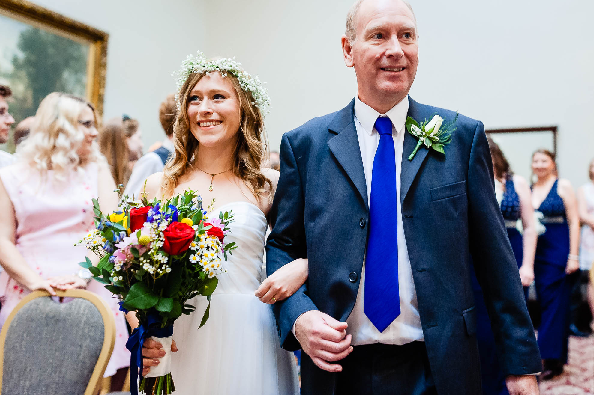 Bride smiles at the groom as she walks down the aisle