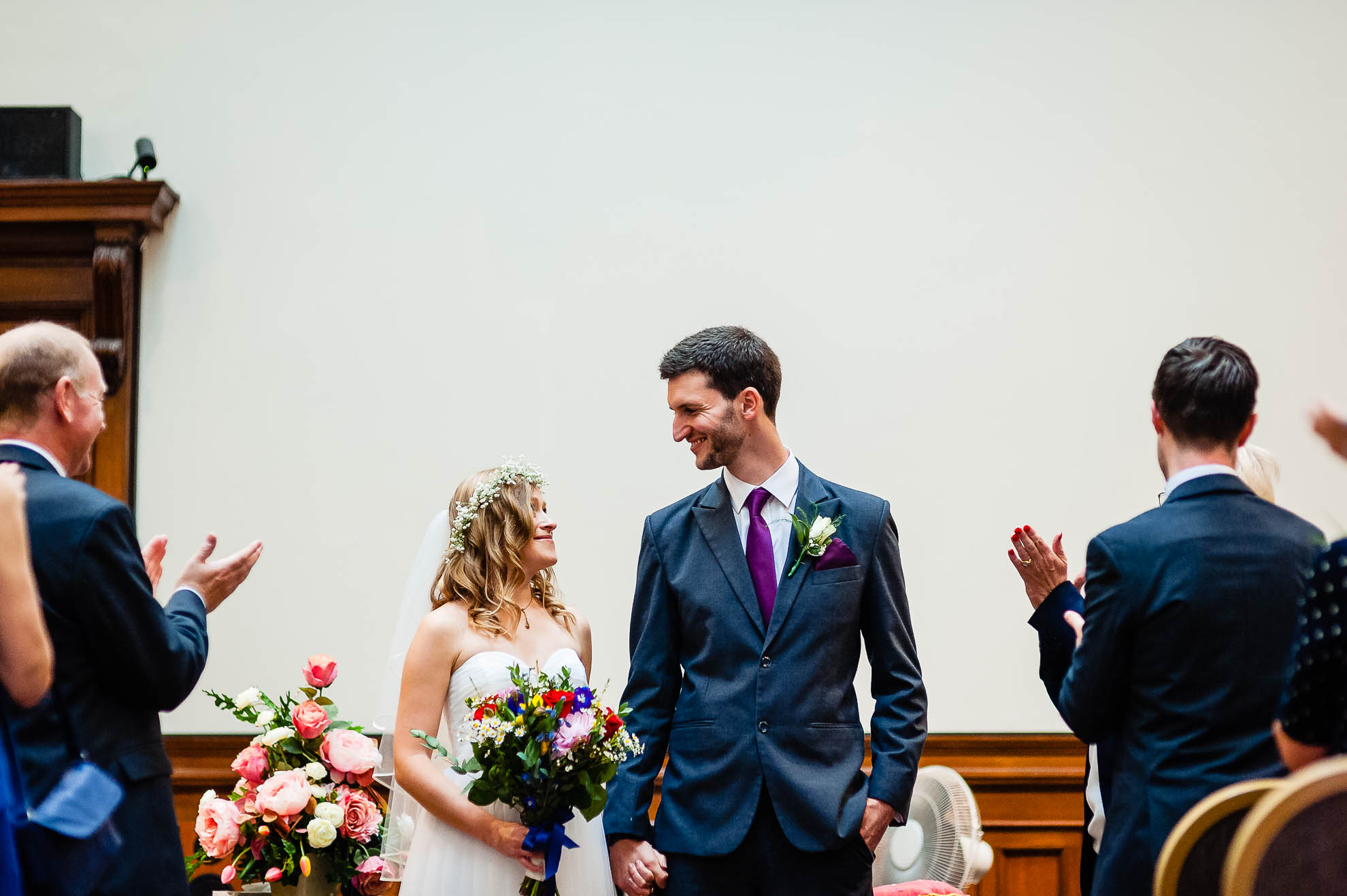 The newly weds smile at each other before they walk back down the aisle