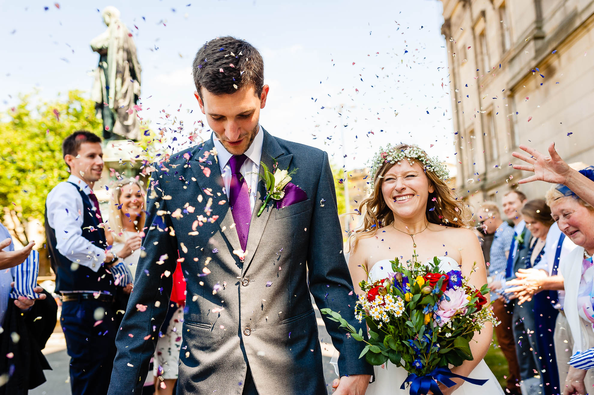 Bride and groom walk through the confetti throw