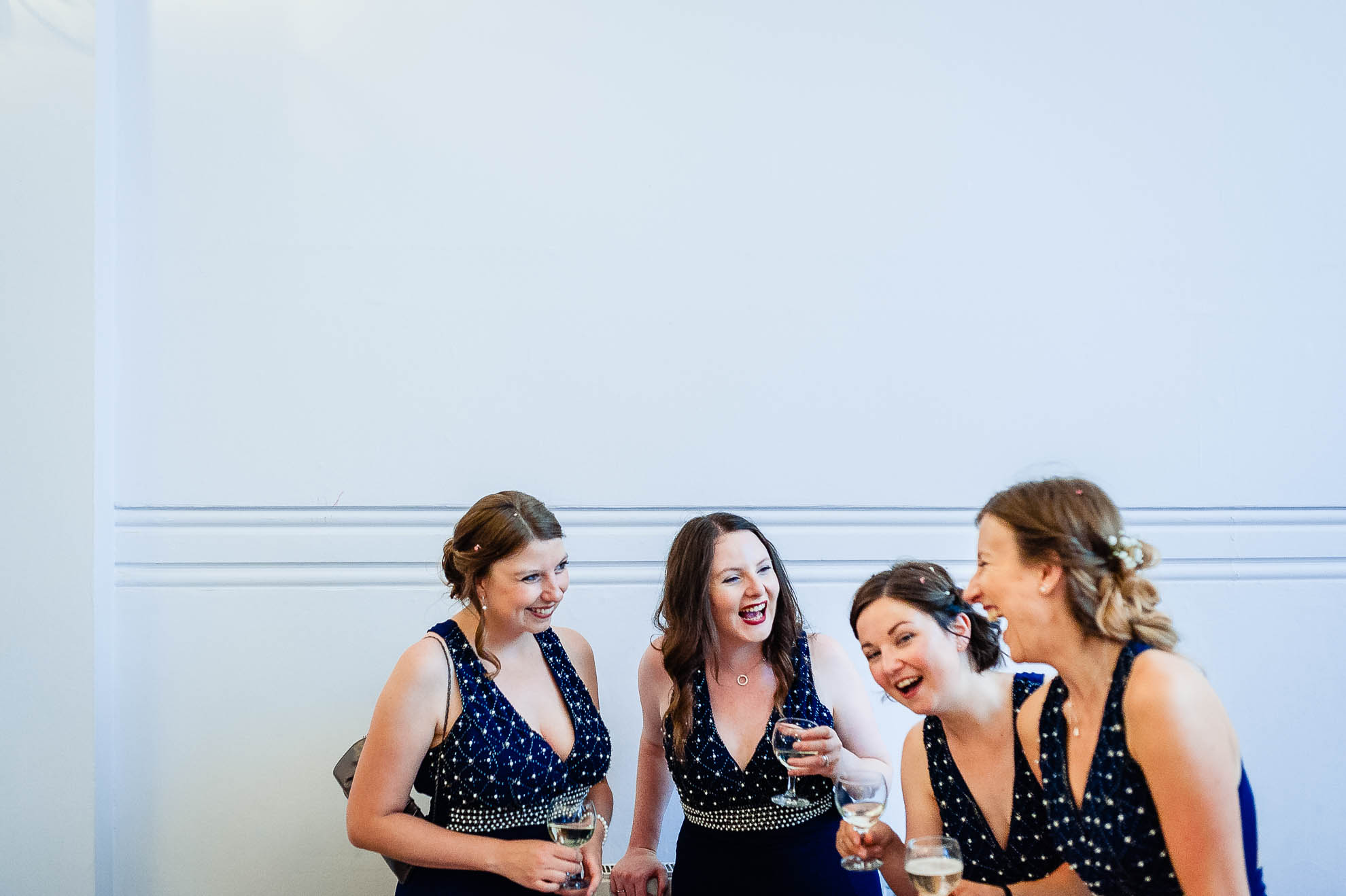 Bridesmaids share a joke during drinks reception