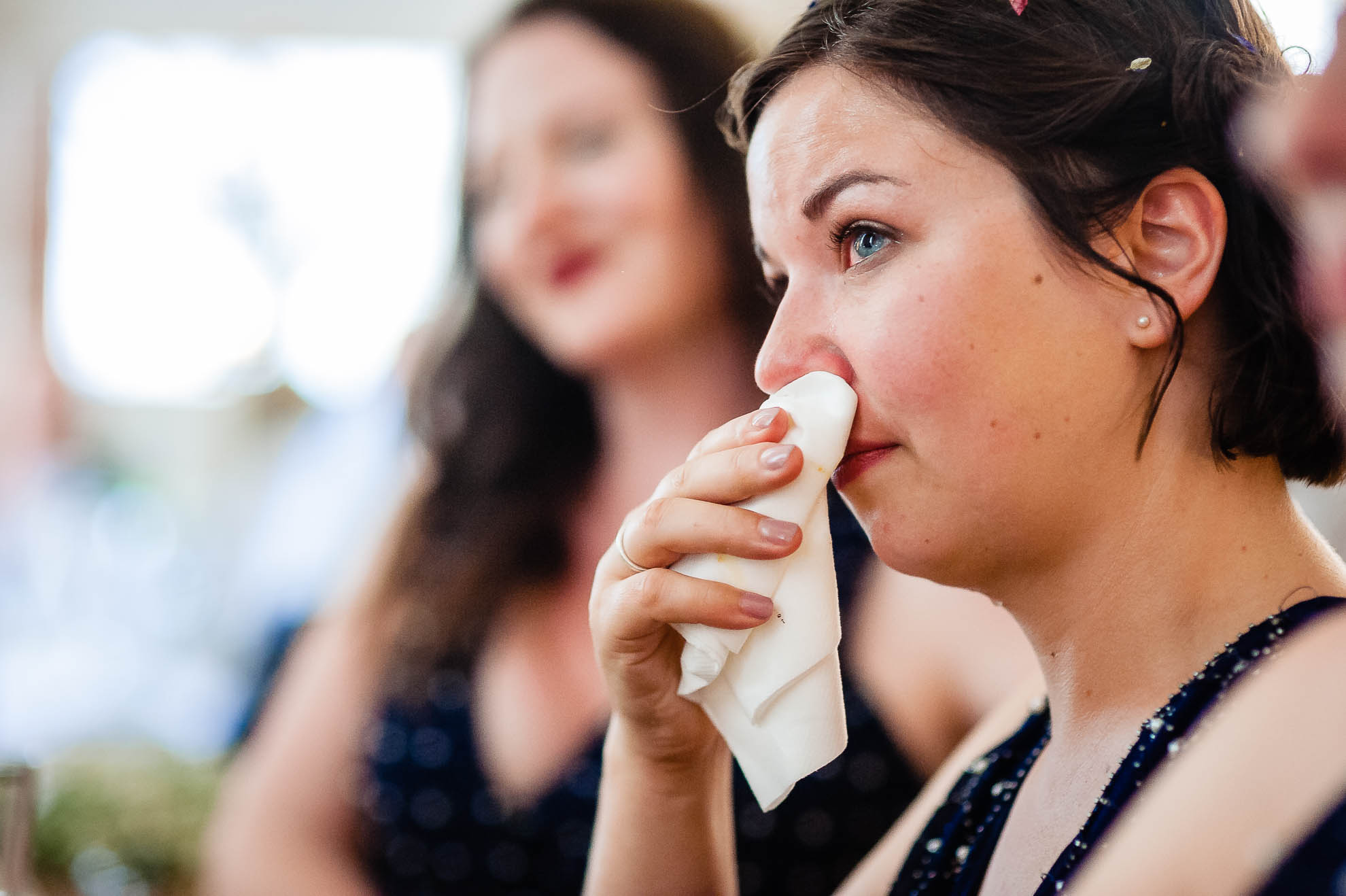Bridesmaid sheds a tear during the groom's speech