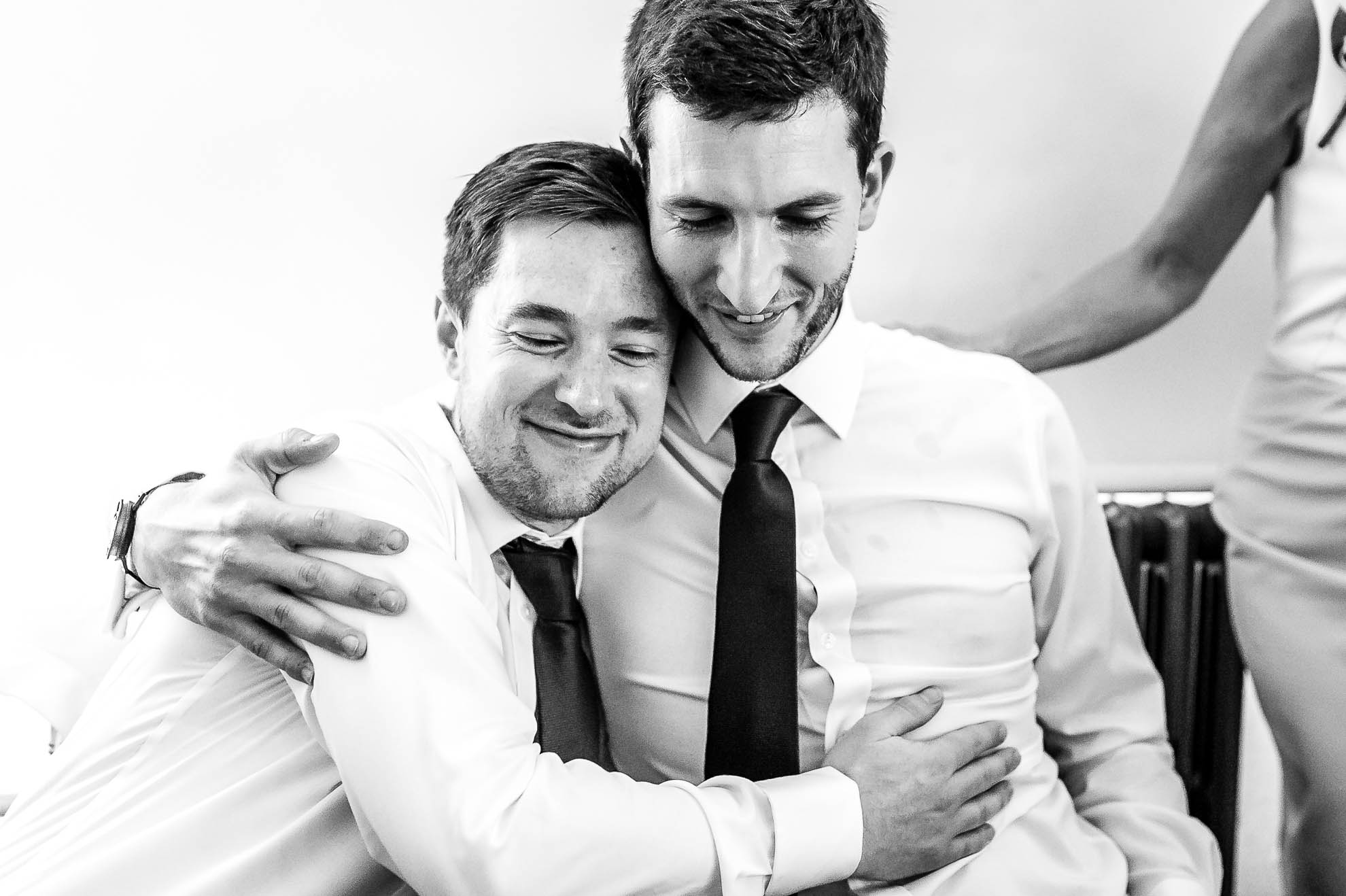Best man and groom hug