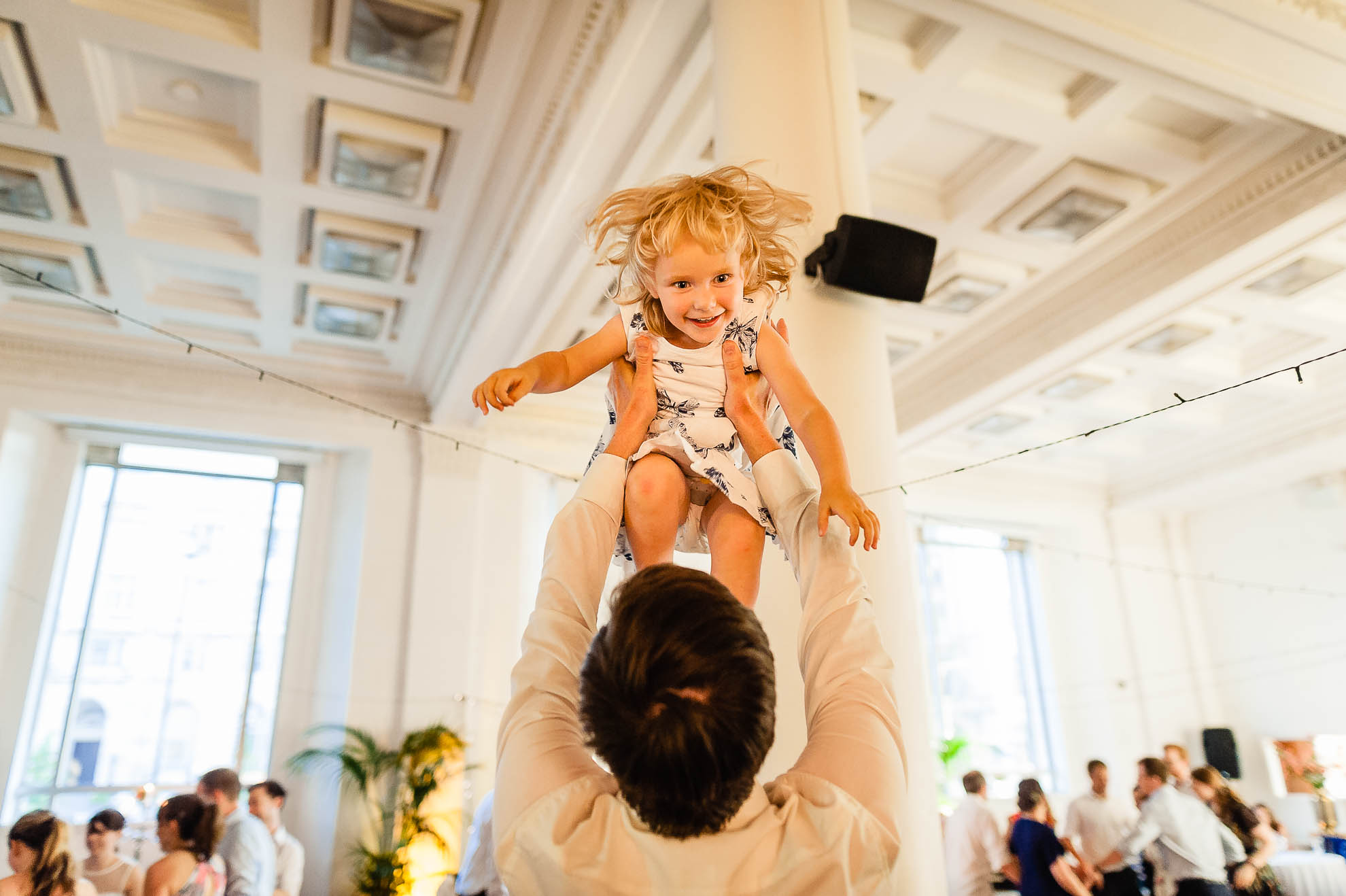 Little girl thrown up in the air during wedding reception
