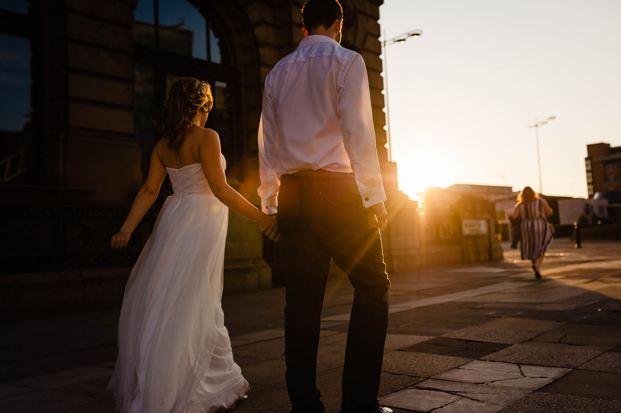 Bride and groom walk past the Liver building