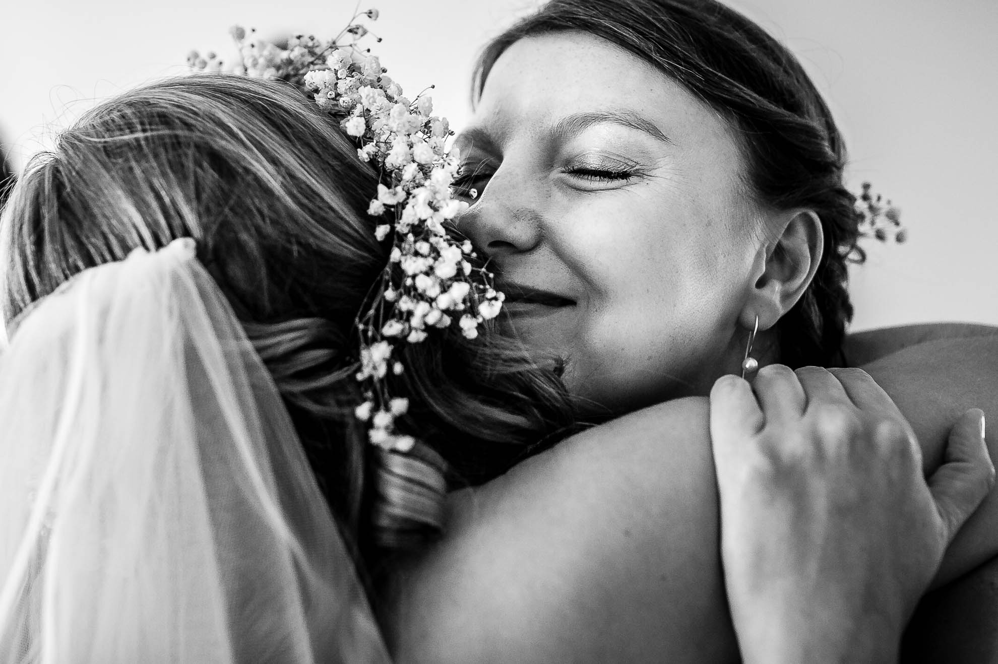 Bridesmaid hugs the bride