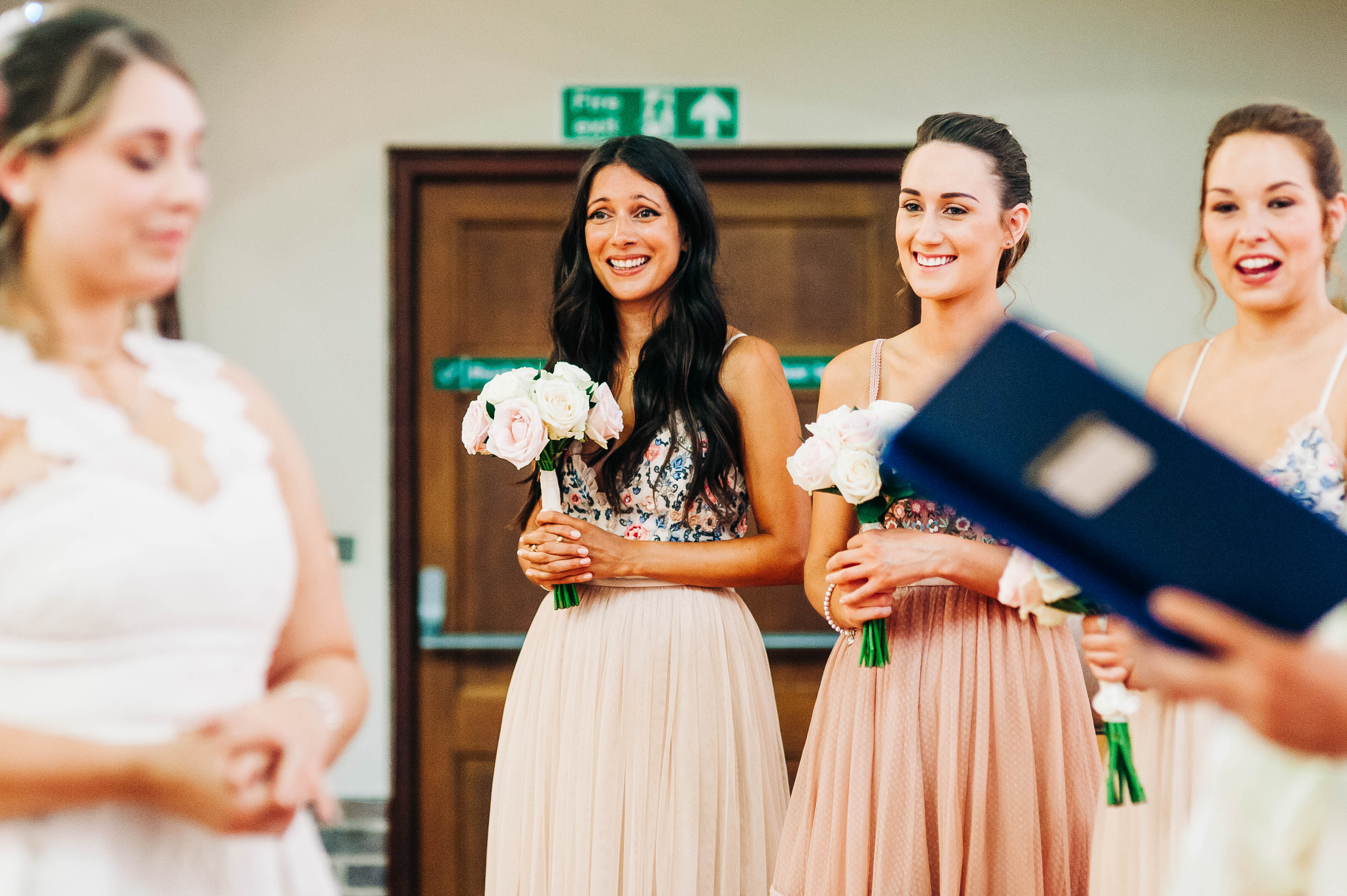 Bridesmaids smile during the ceremony
