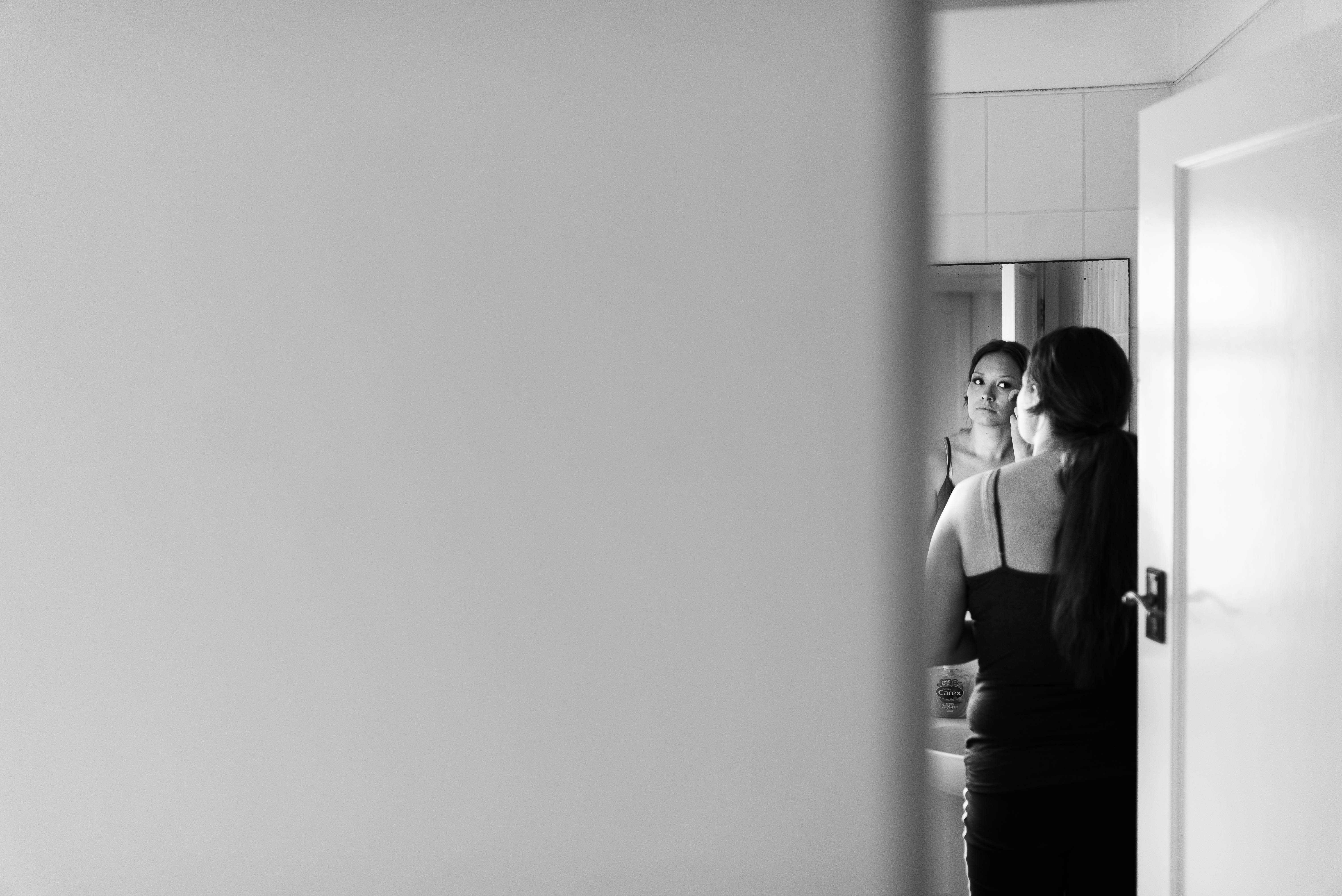 Bridesmaid applies make up in mirror