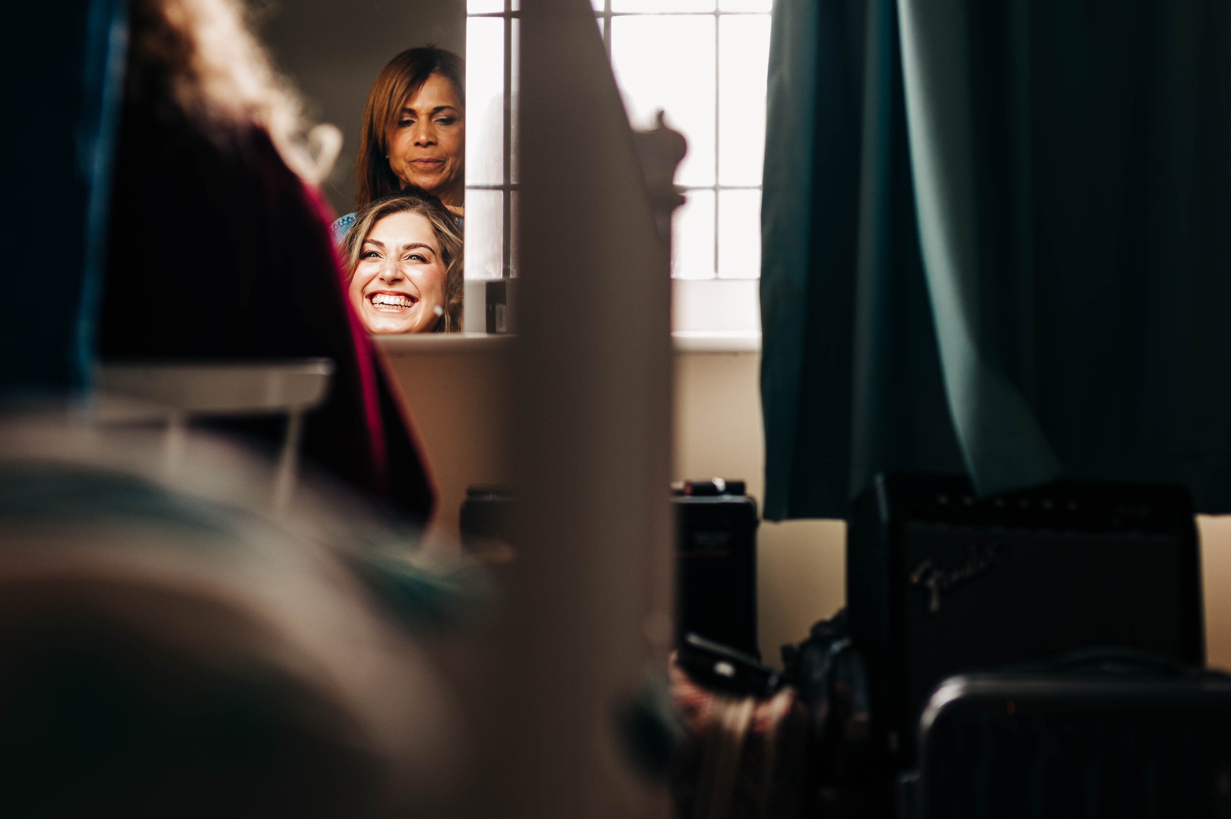 Bride laughs as she has her hair done