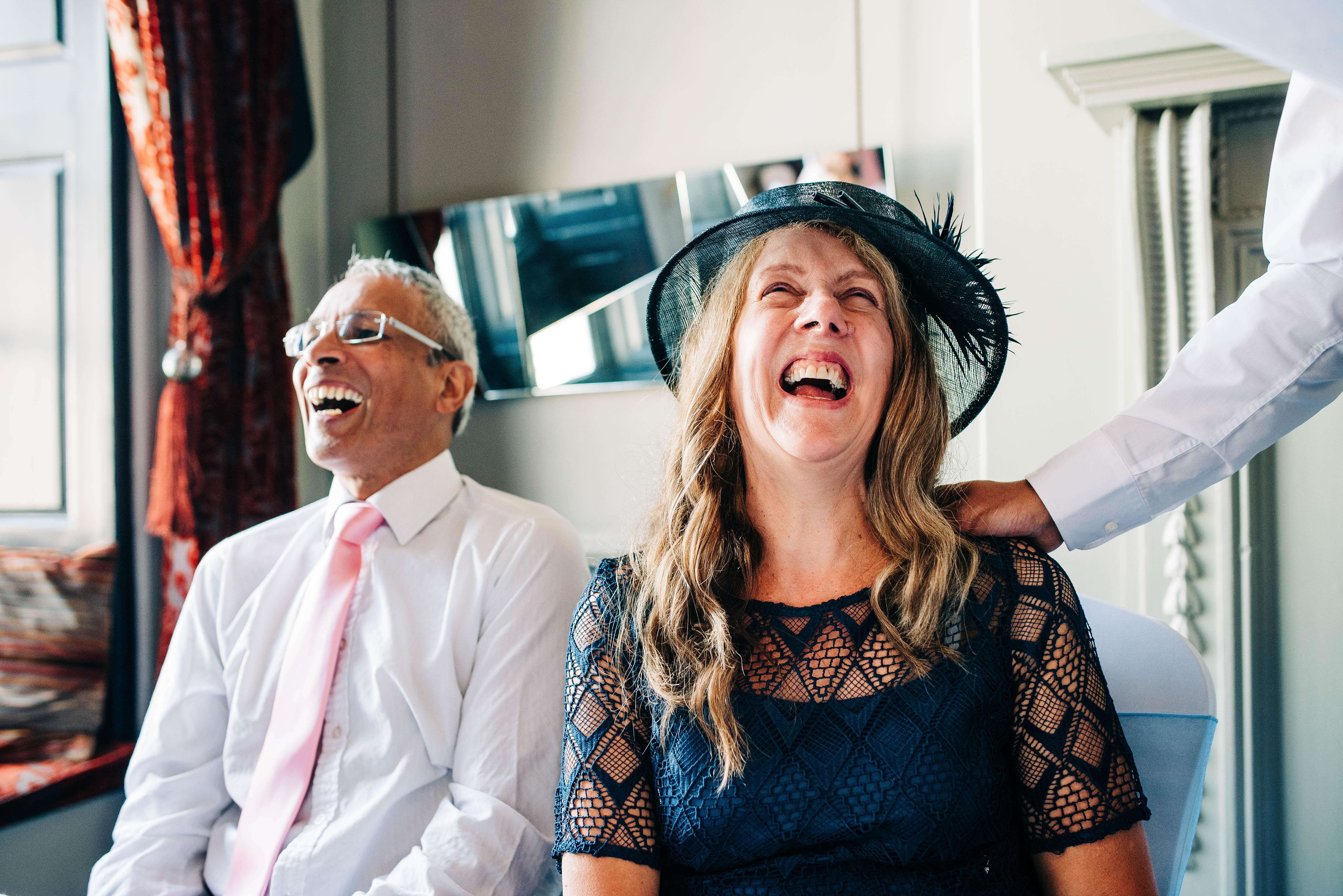 Mother & father of the groom laugh at grooms speech