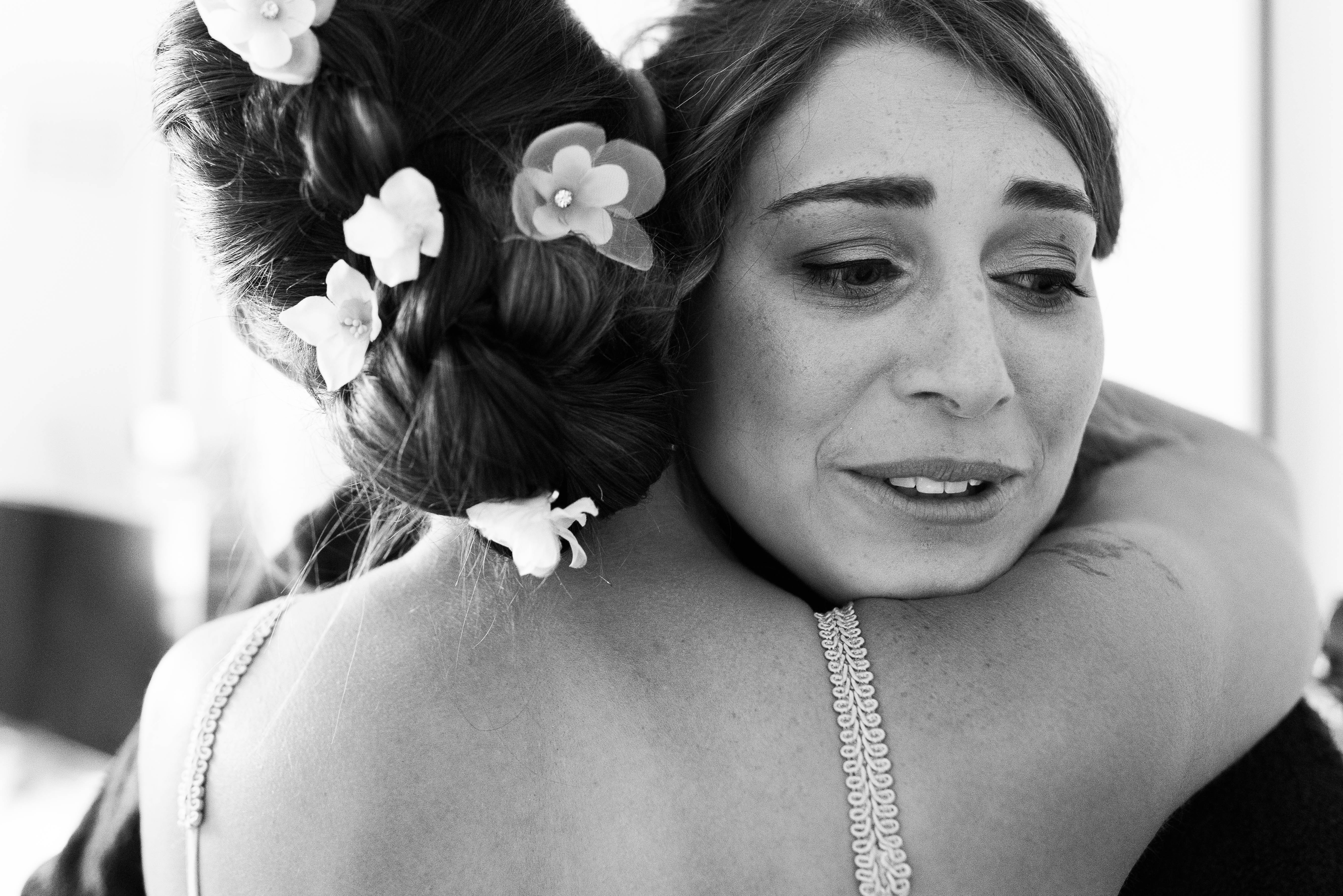 Bridesmaid hugs the bride