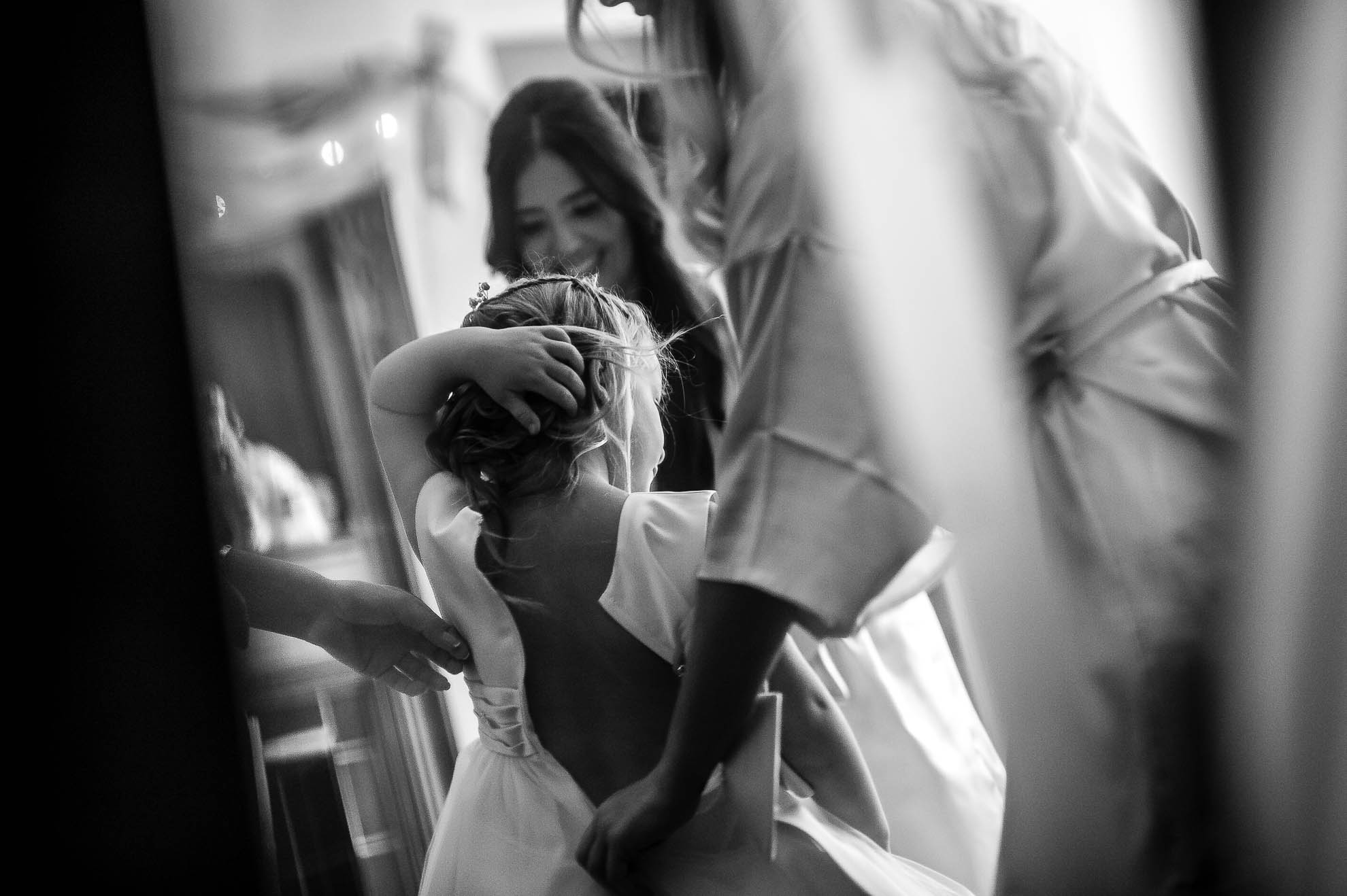 Flower girl is helped into her dress