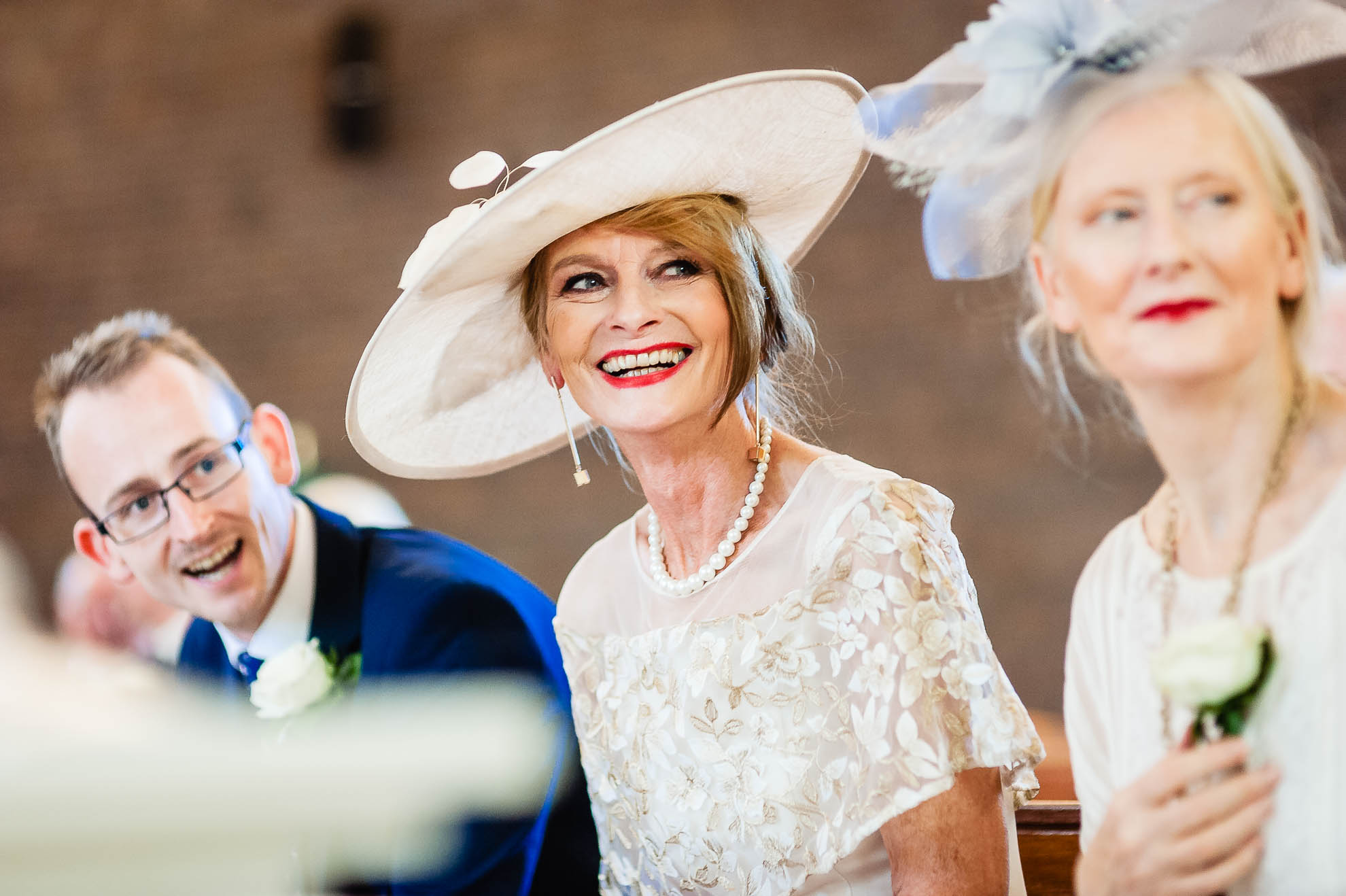 Mother of the groom smiles as she watches the bride enter the church