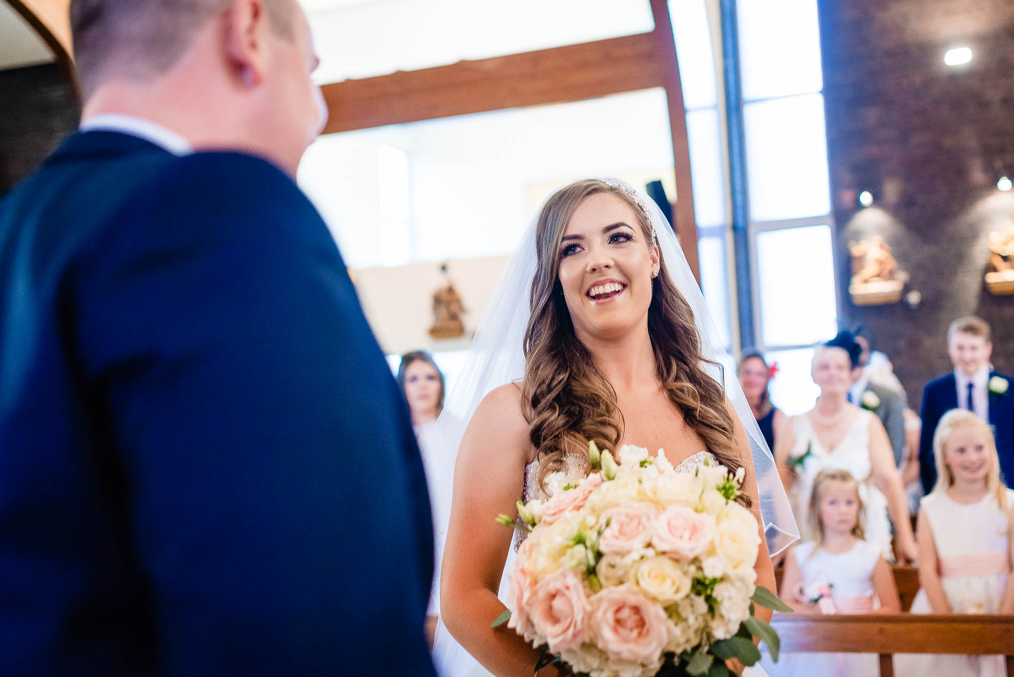 Bride smiles at the groom as she arrives at the altar