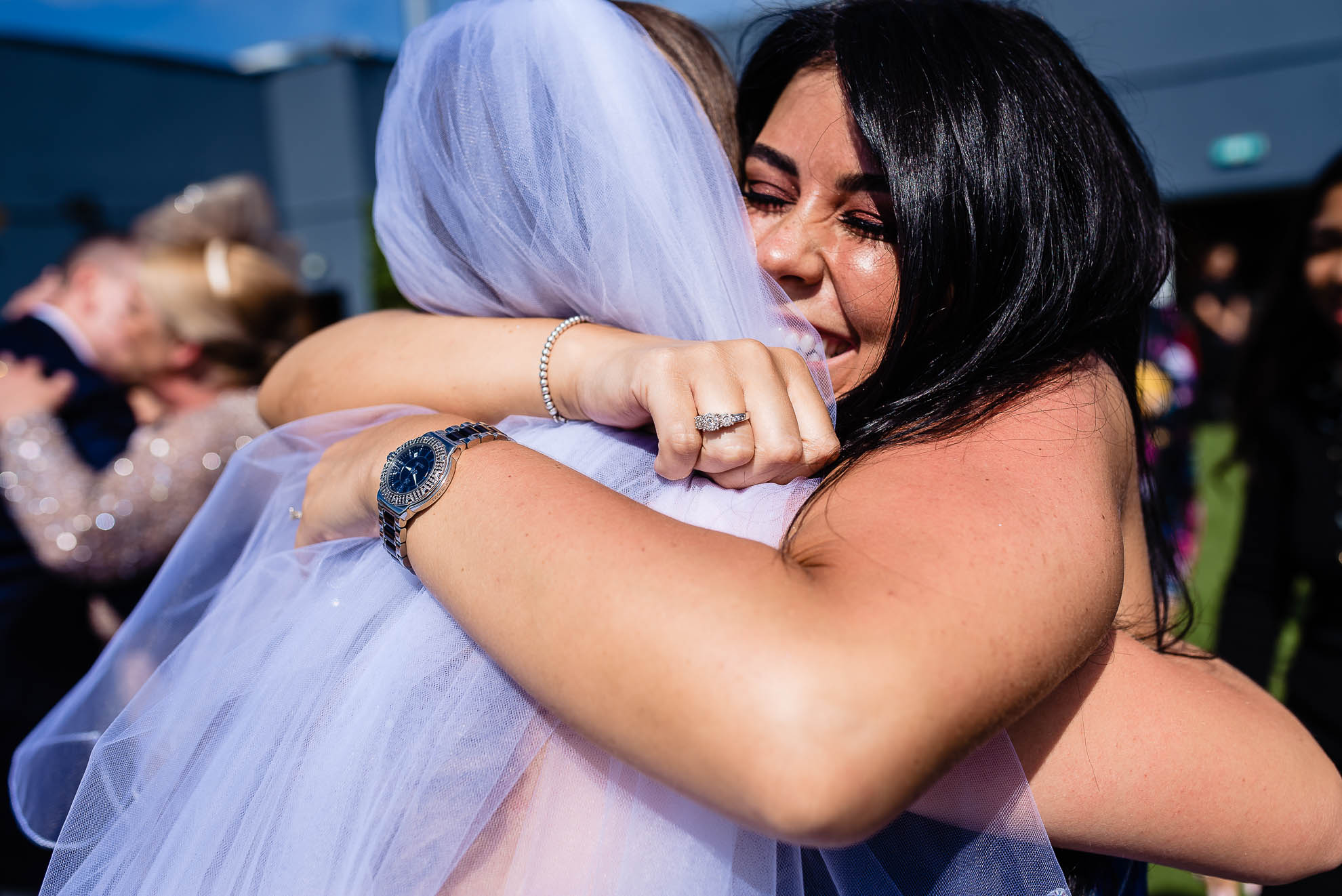 bride gets a big hug from a wedding guest