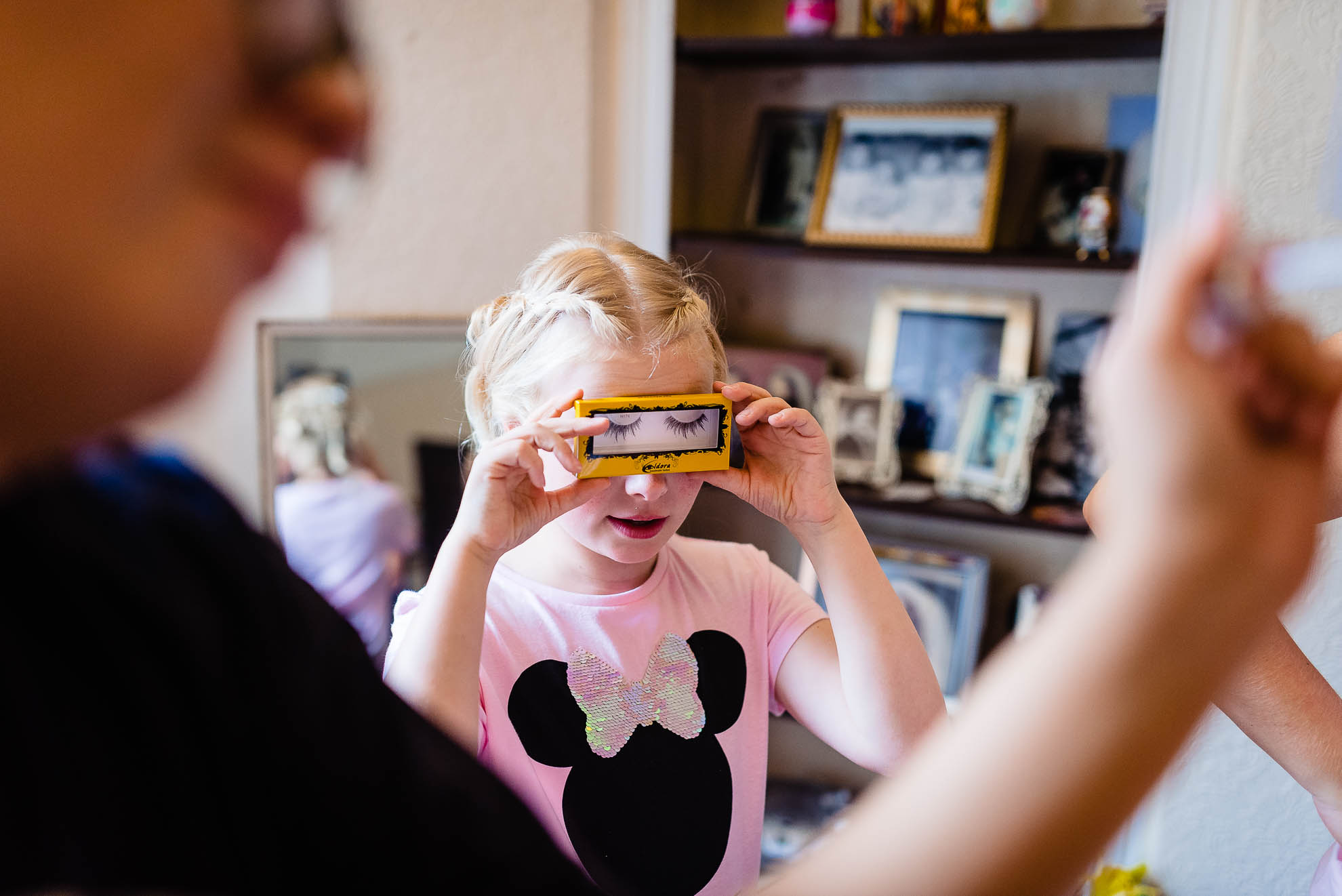 Flower girl playing with false eyelashes