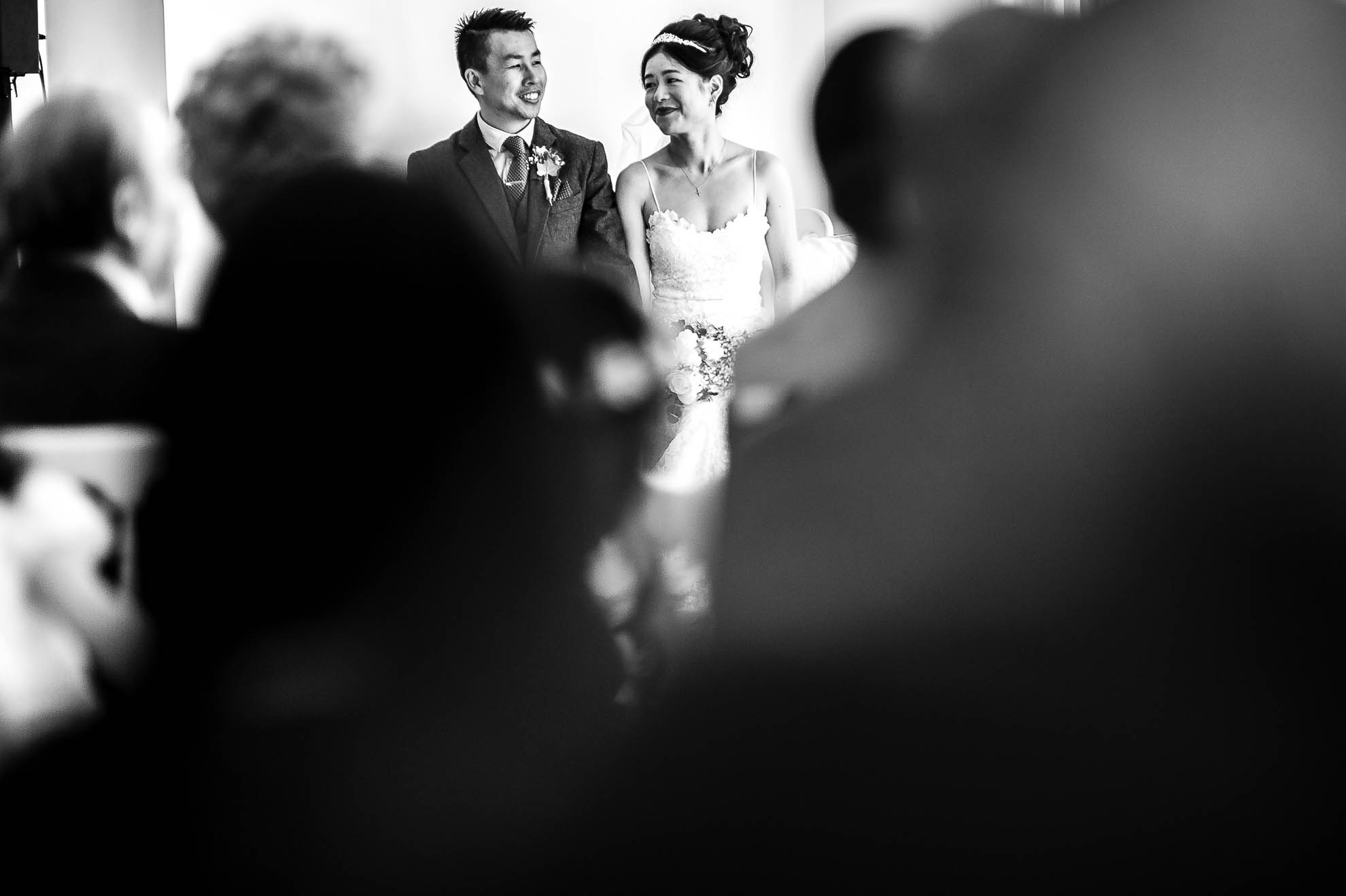 Bride looks at groom and smiles during wedding ceremony