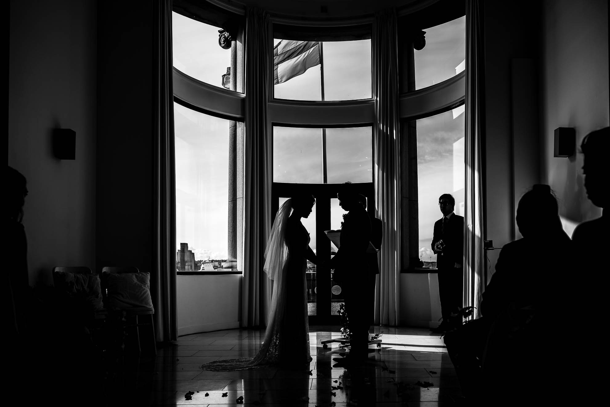 Silhouette of bride and groom exchanging vows