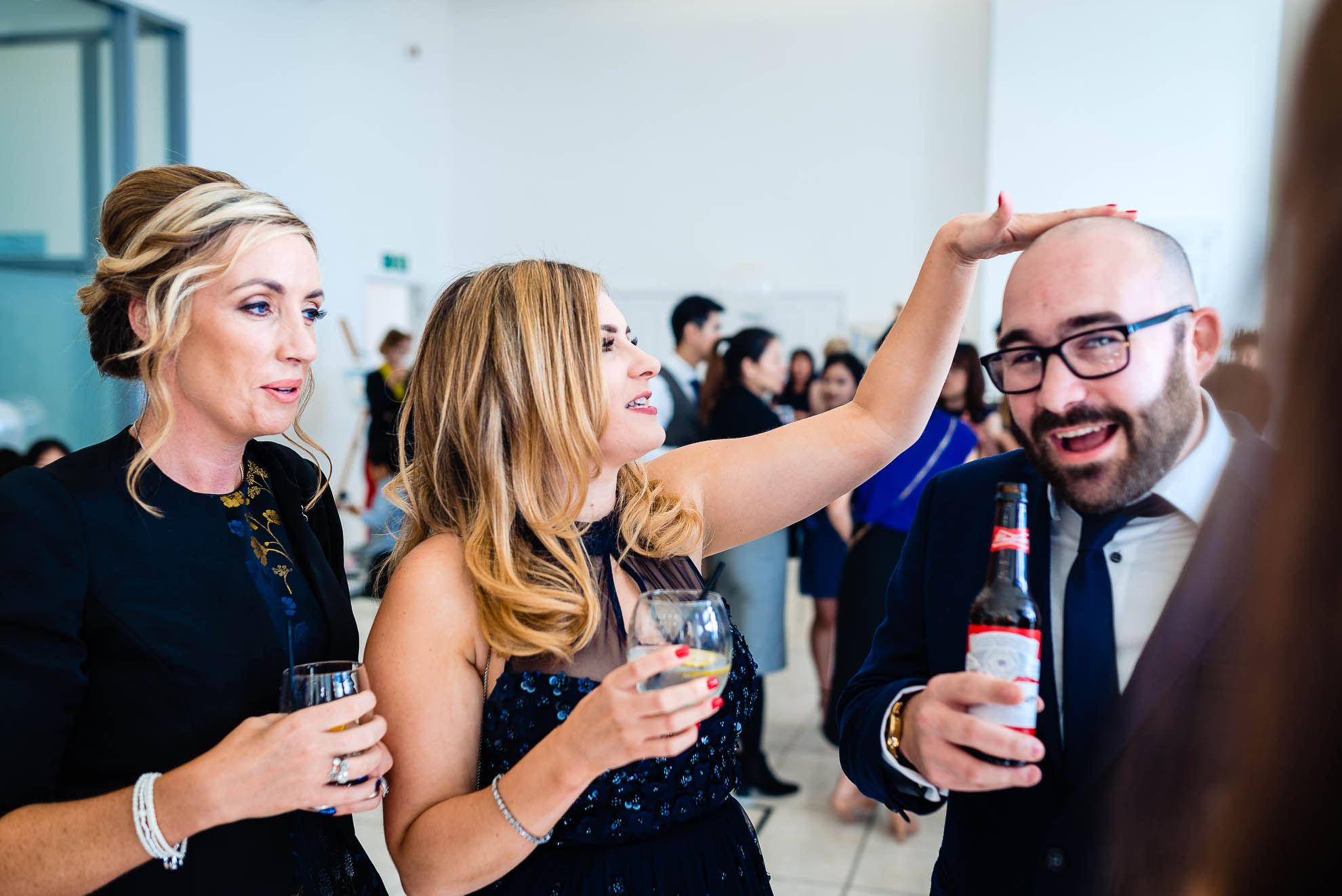 Woman wedding guest taps male guest on head