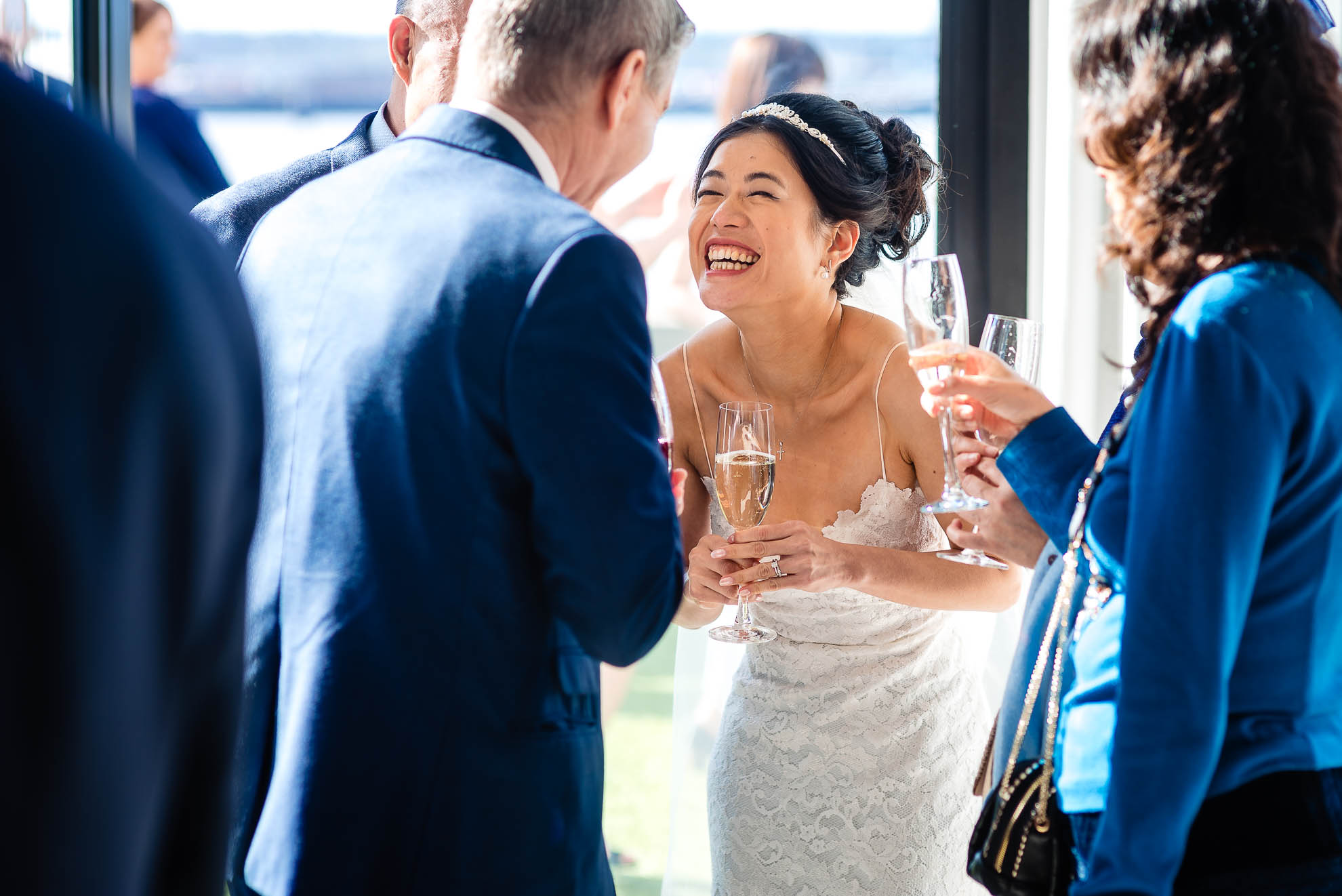 Bride shares a joke with wedding celebrant during drinks reception