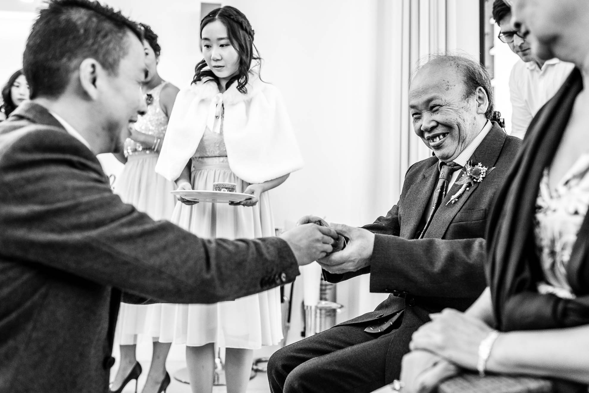 Groom gives his father tea during the tea ceremony
