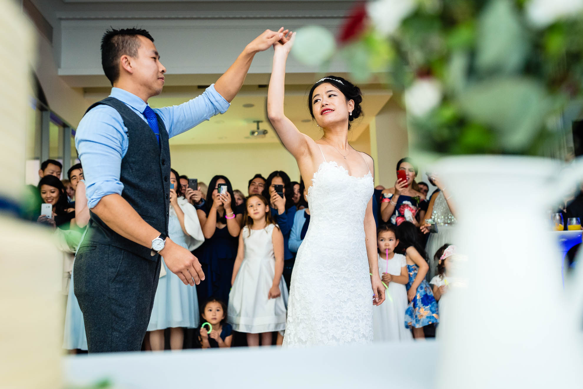 Bride and groom hold hands during first dance