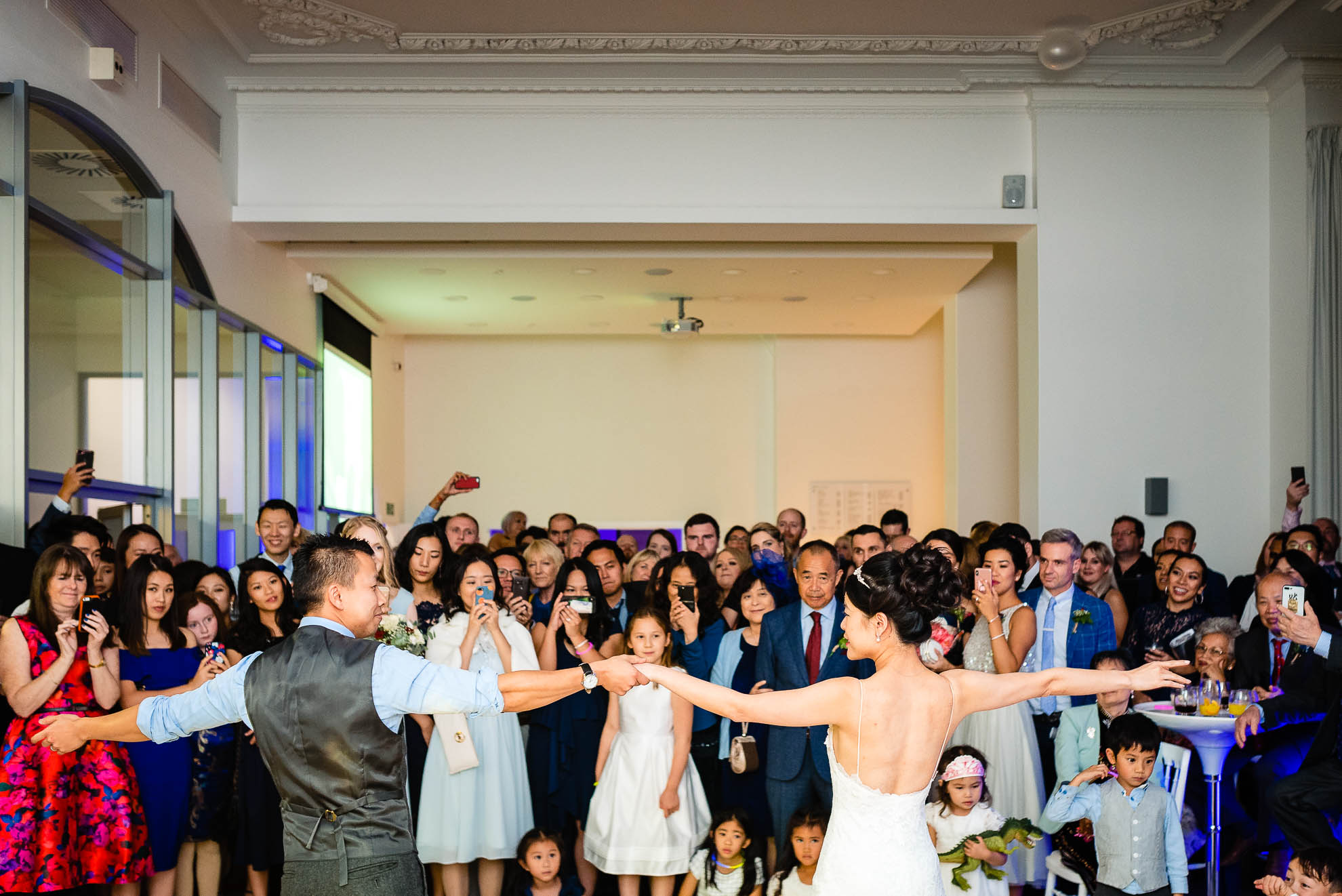 Bride and groom first dance with all guests watching