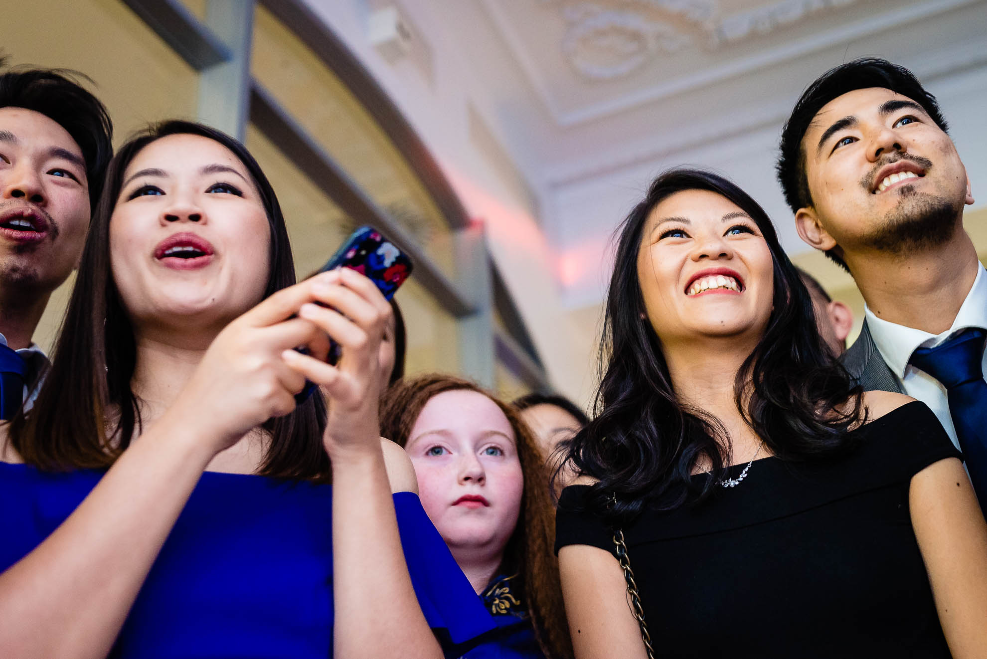 Wedding guests smile as they watch the first dance