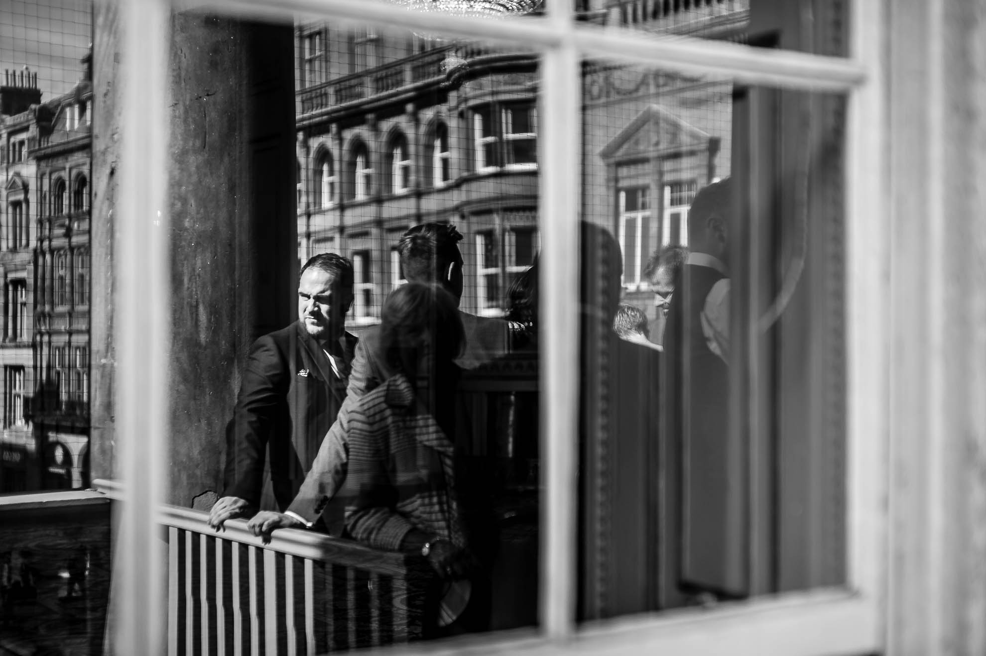 Guest reflection in window on town hall balcony