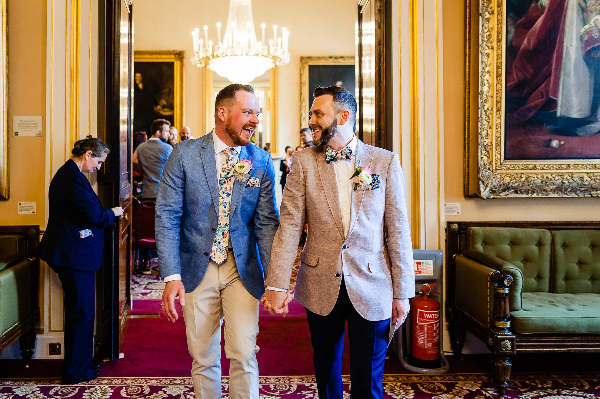The newlyweds laugh together as they walk out of the ceremony room