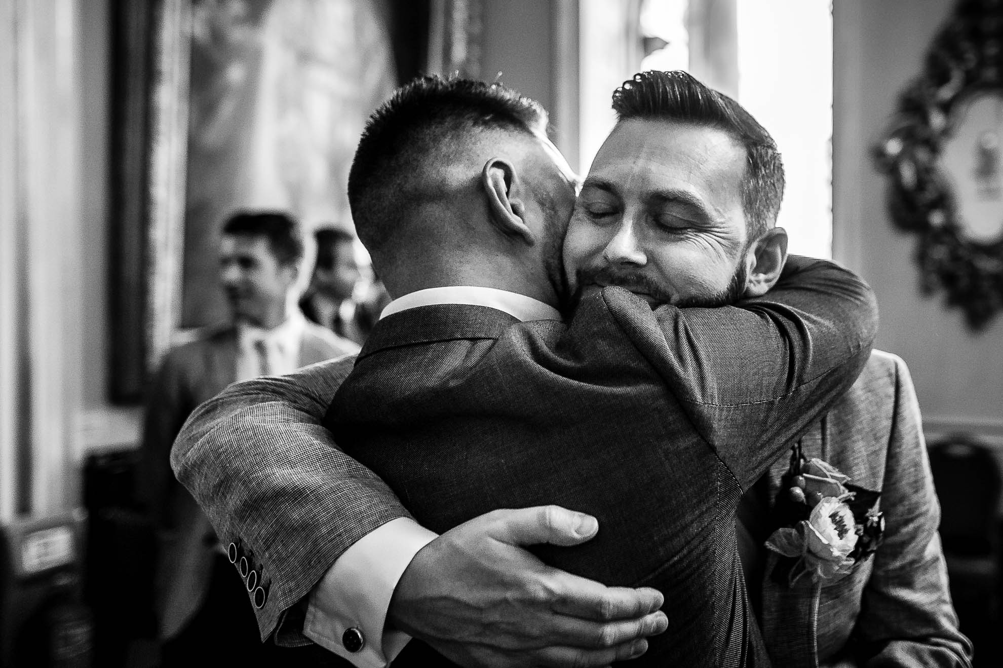 Guest hugs groom after wedding ceremony
