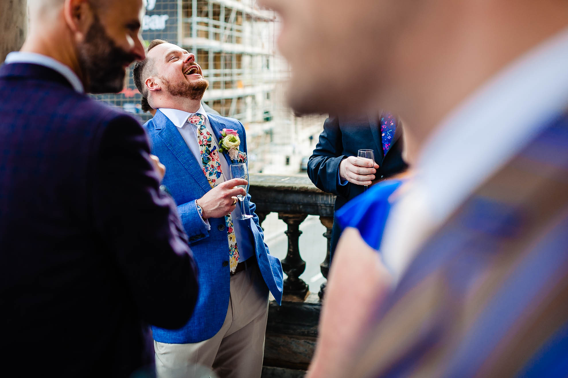 Groom enjoying a drink with guests during drinks reception