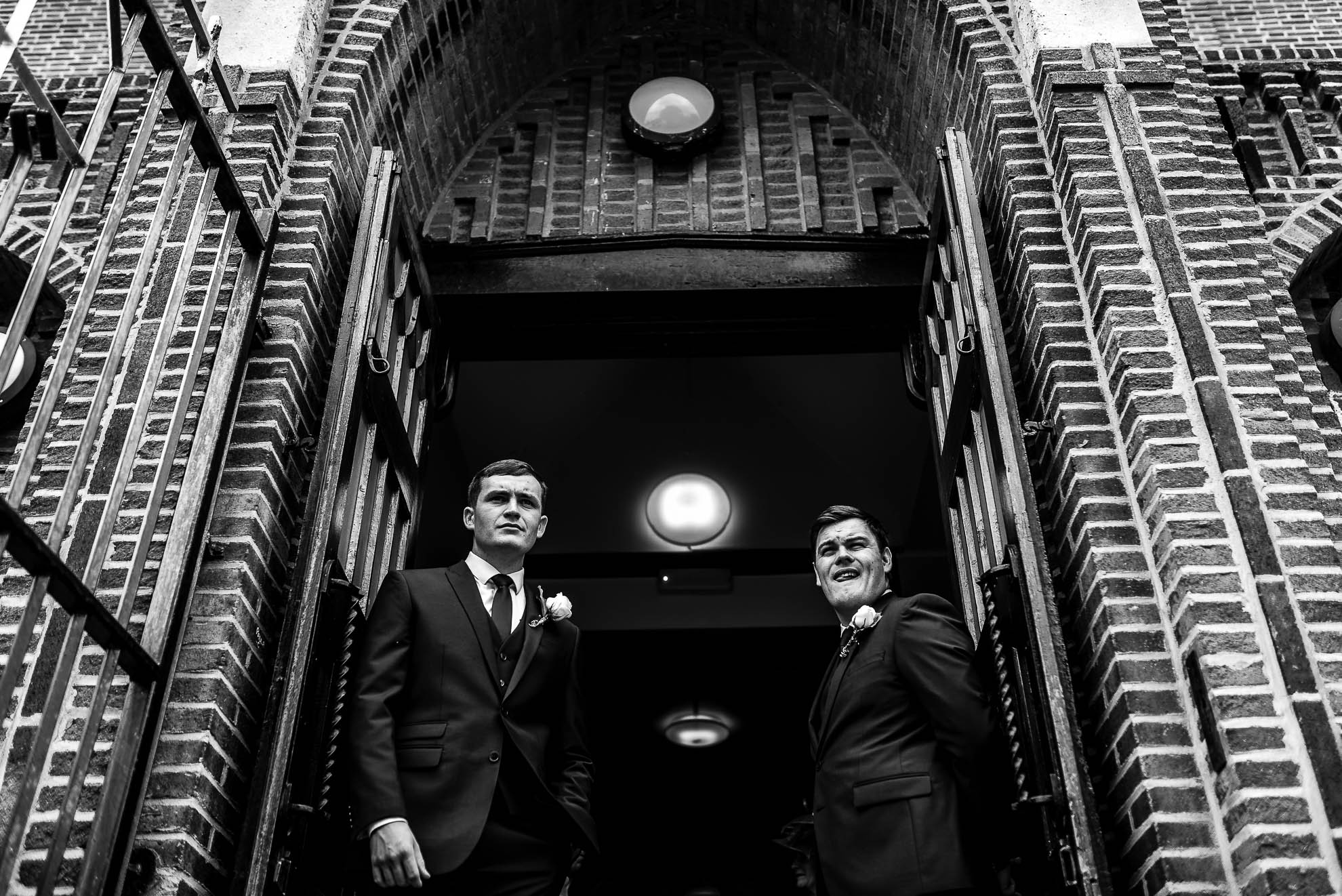 Best man and ushers wait at entrance to church
