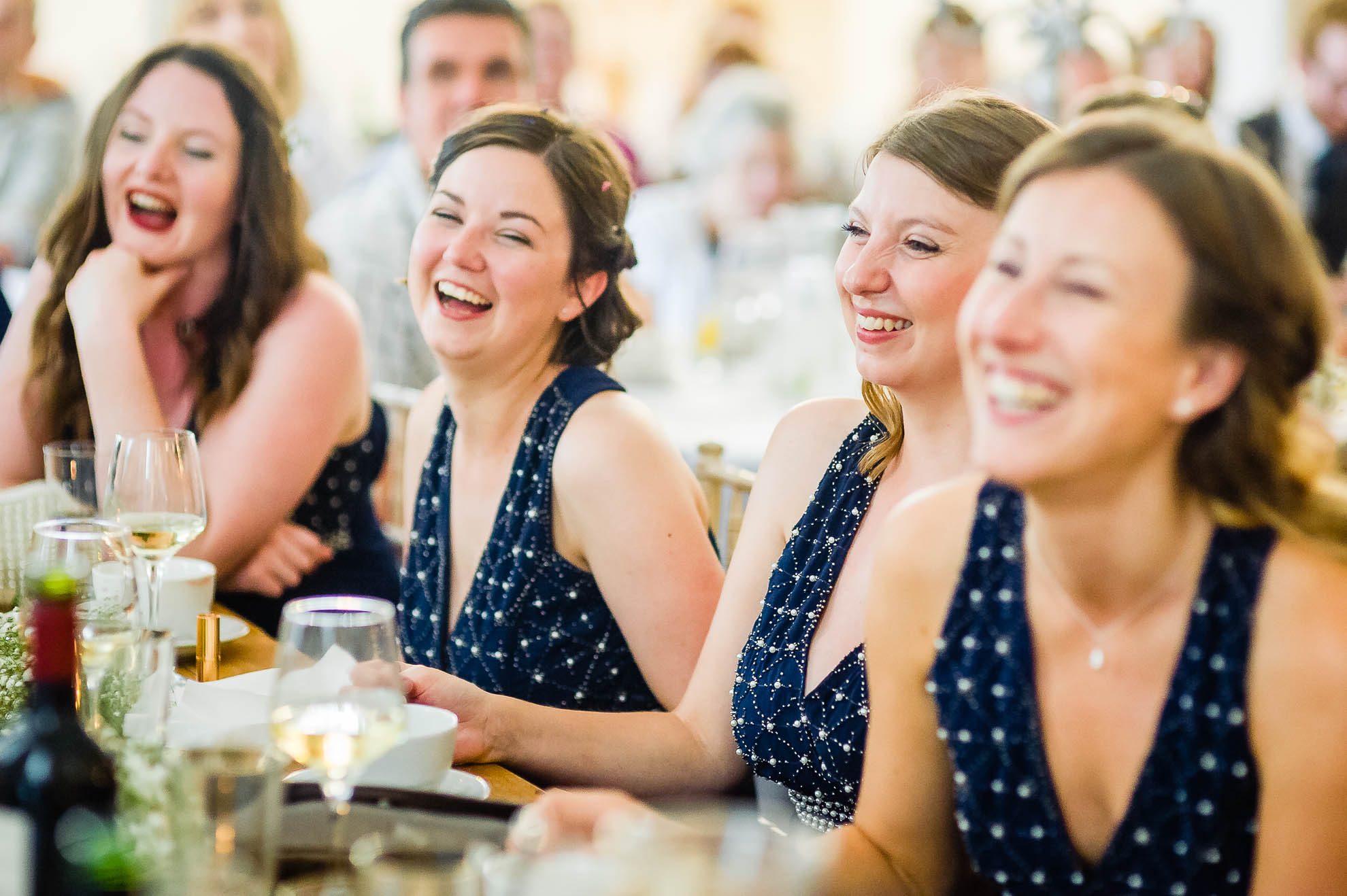 Bridesmaids laugh at grooms speech
