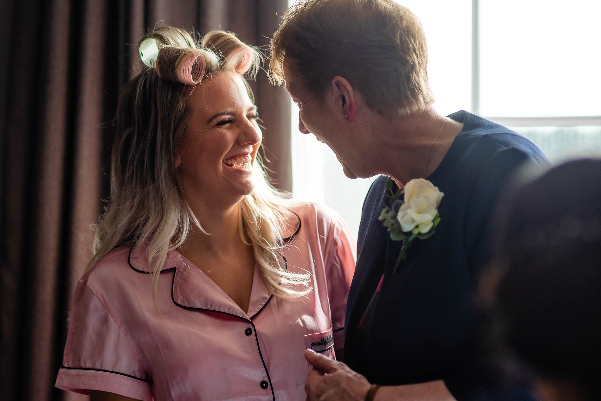 Bridesmaid and mother of the bride share a joke
