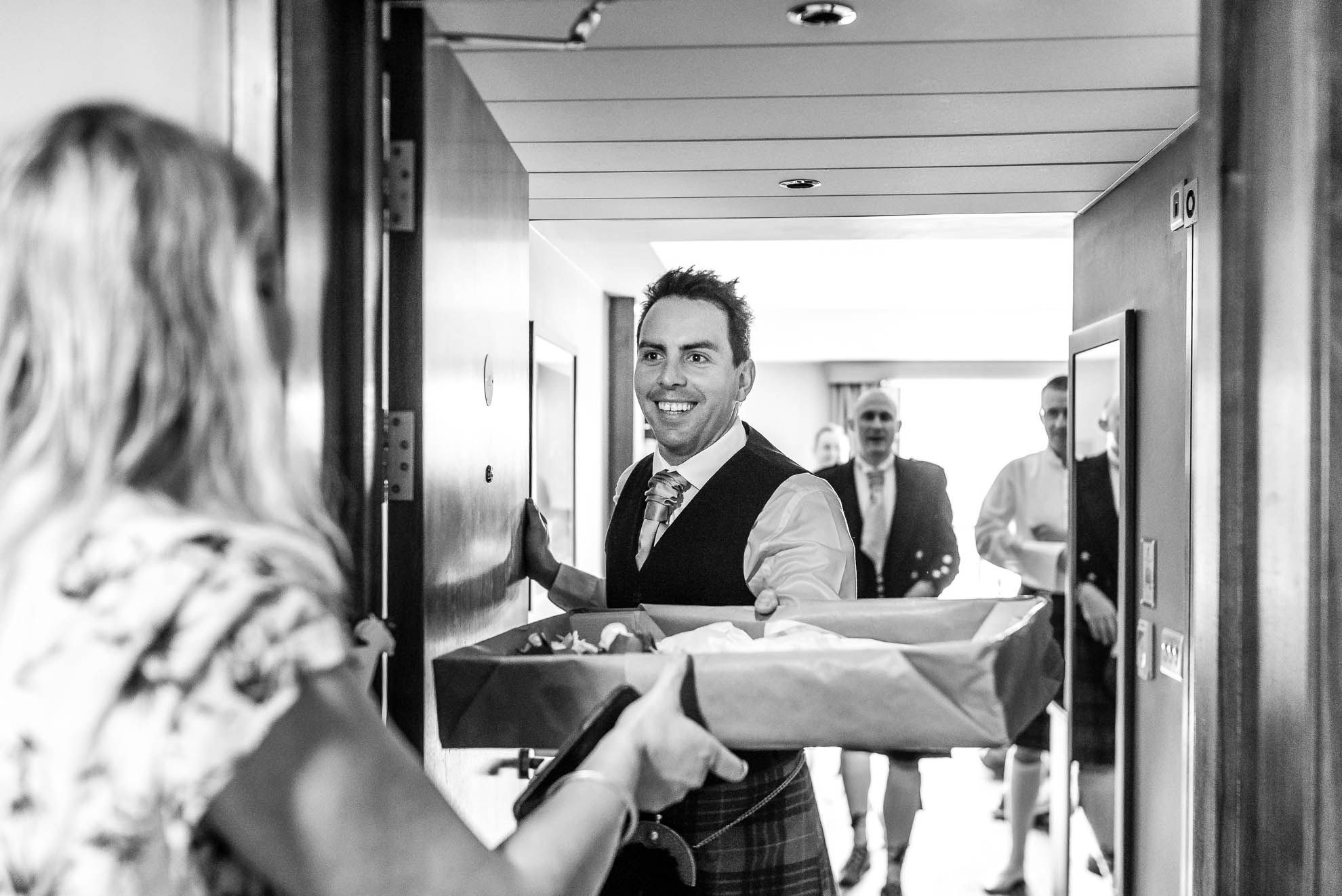 Usher collects the wedding buttonholes at the door 
