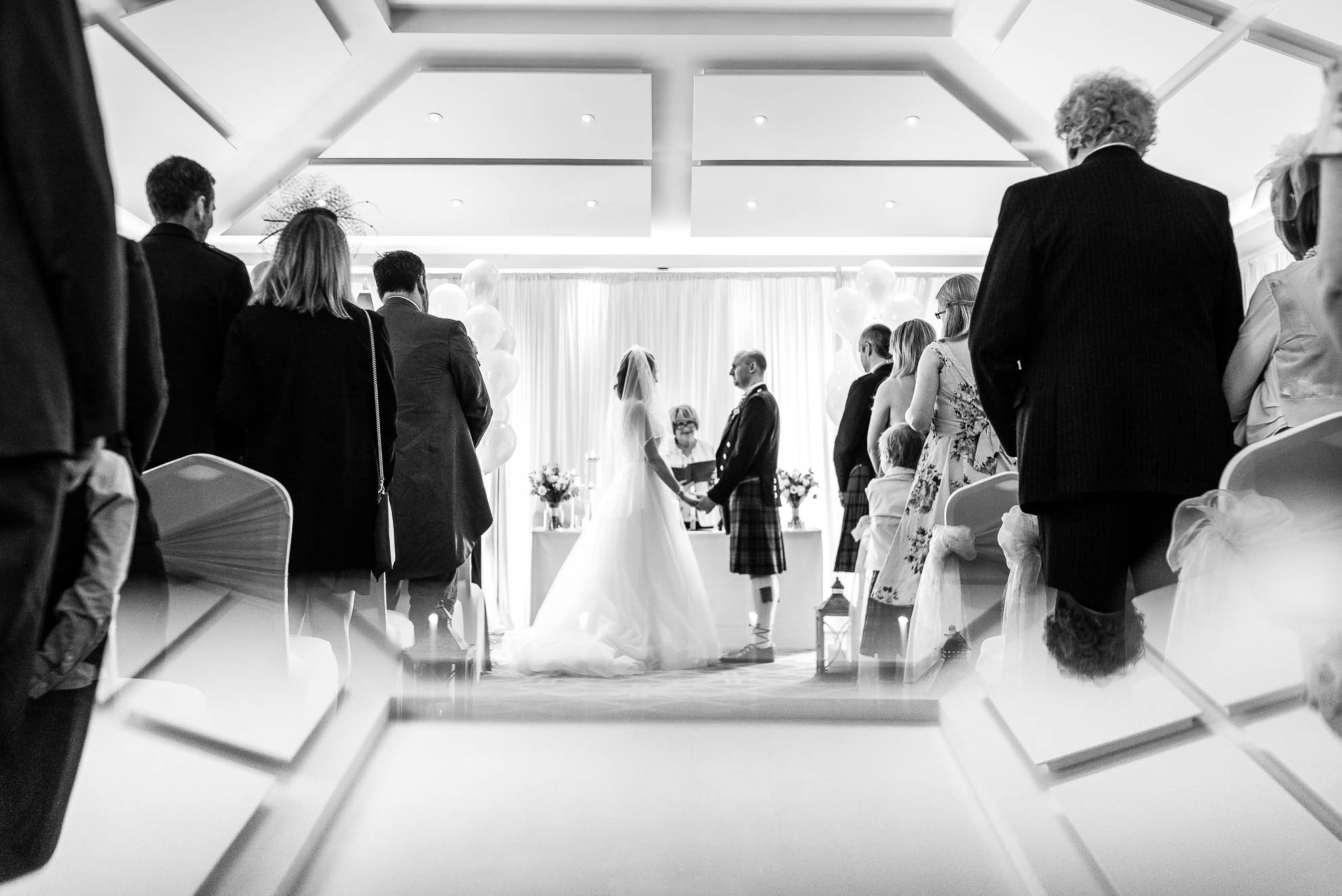 Bride and groom face each other as the exchange rings