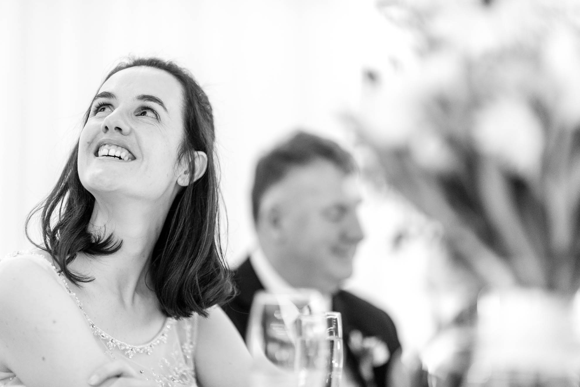 Bride smiles during grooms speech