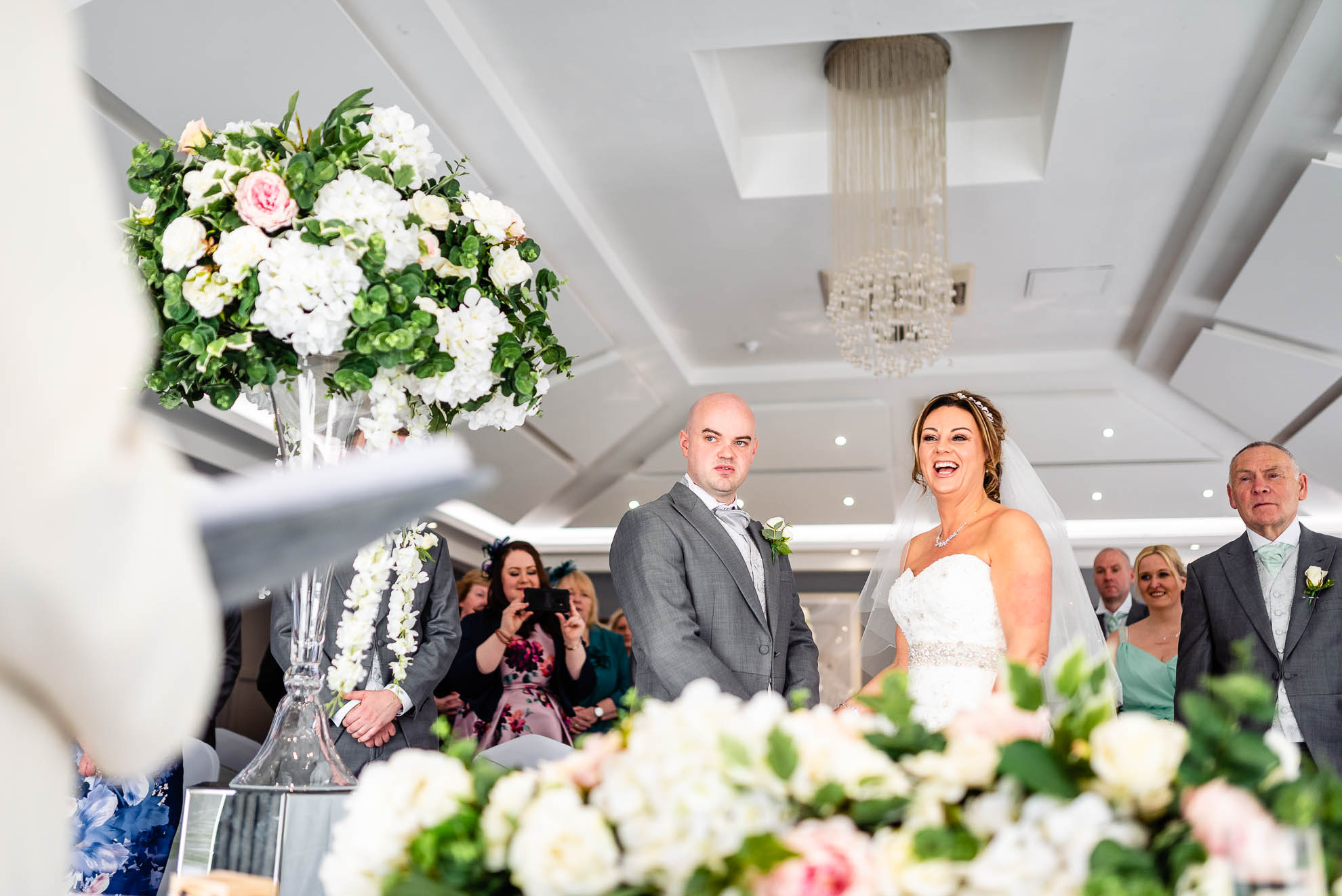 Bride and groom share a joke with registrar