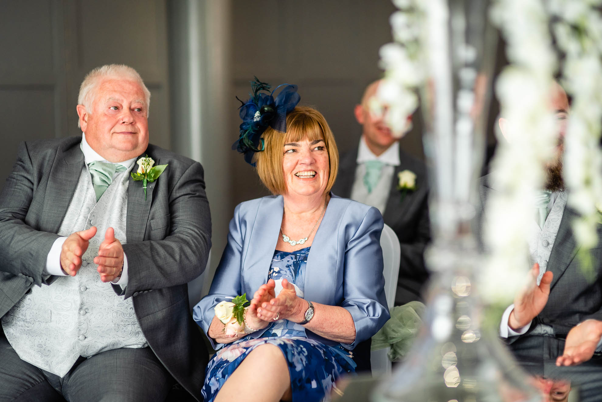 Mother and father of the groom applauding the happy couple