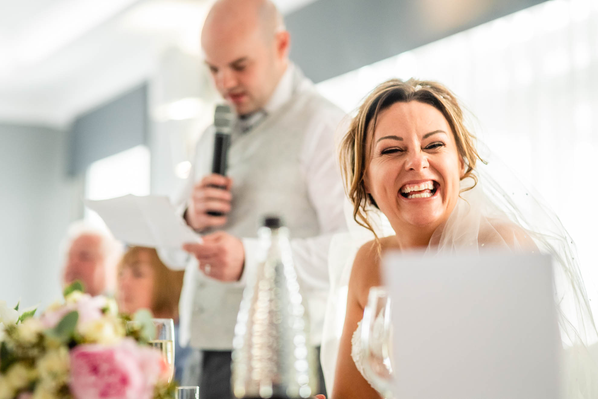 Bride laughing at grooms speech