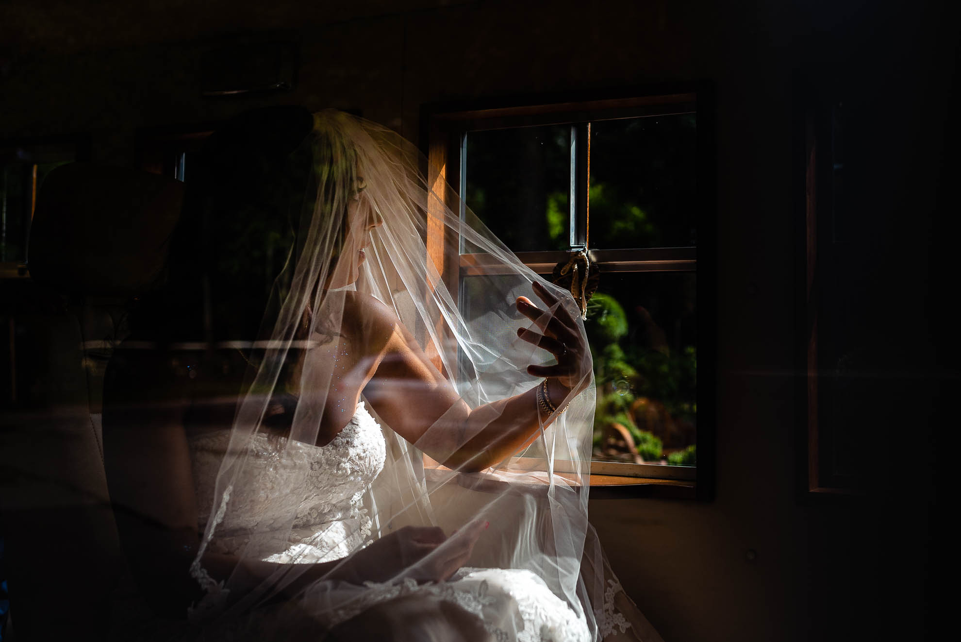 The bride looks out of the wedding car window